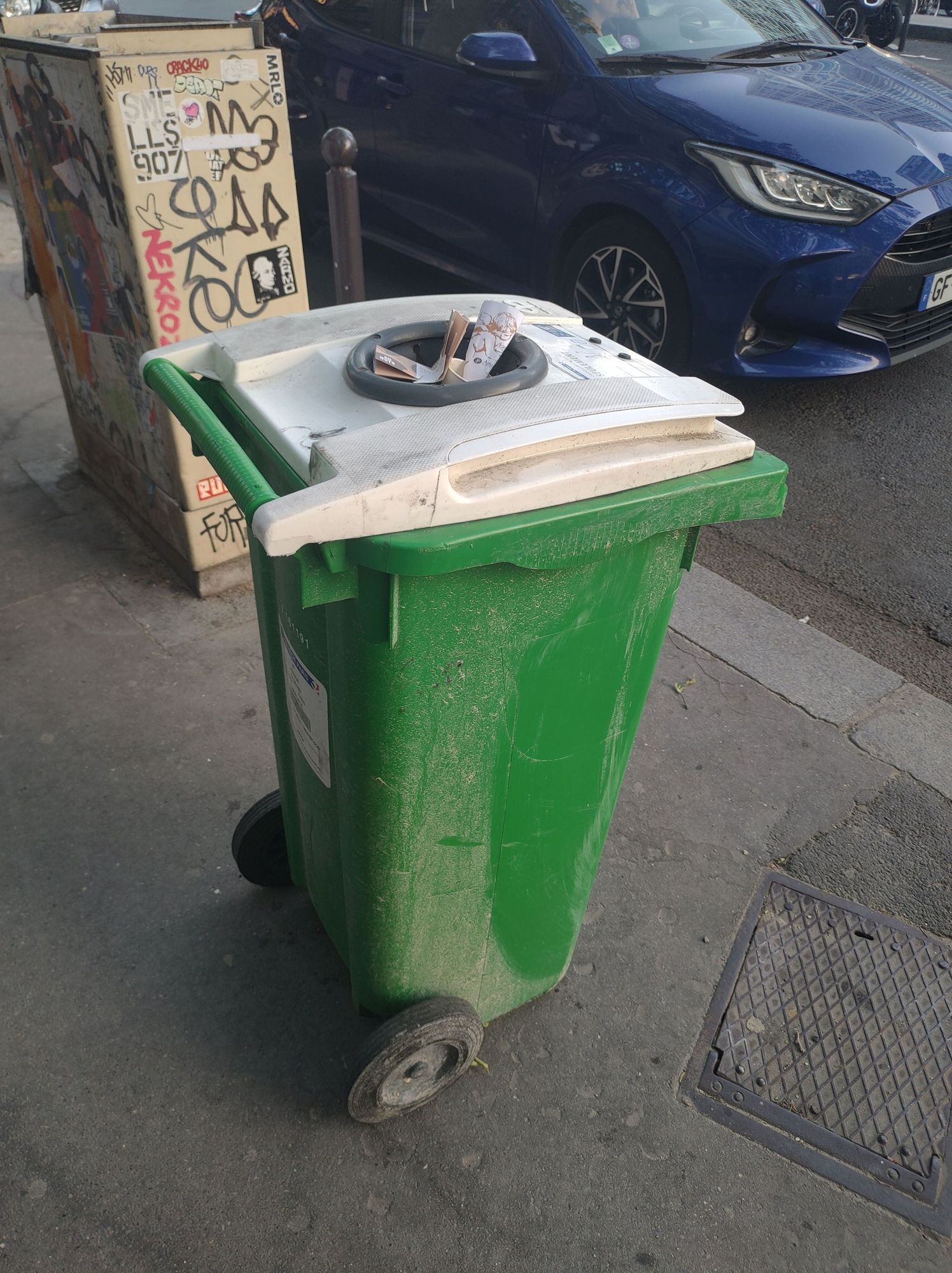 Green toter trash bin in Paris. 