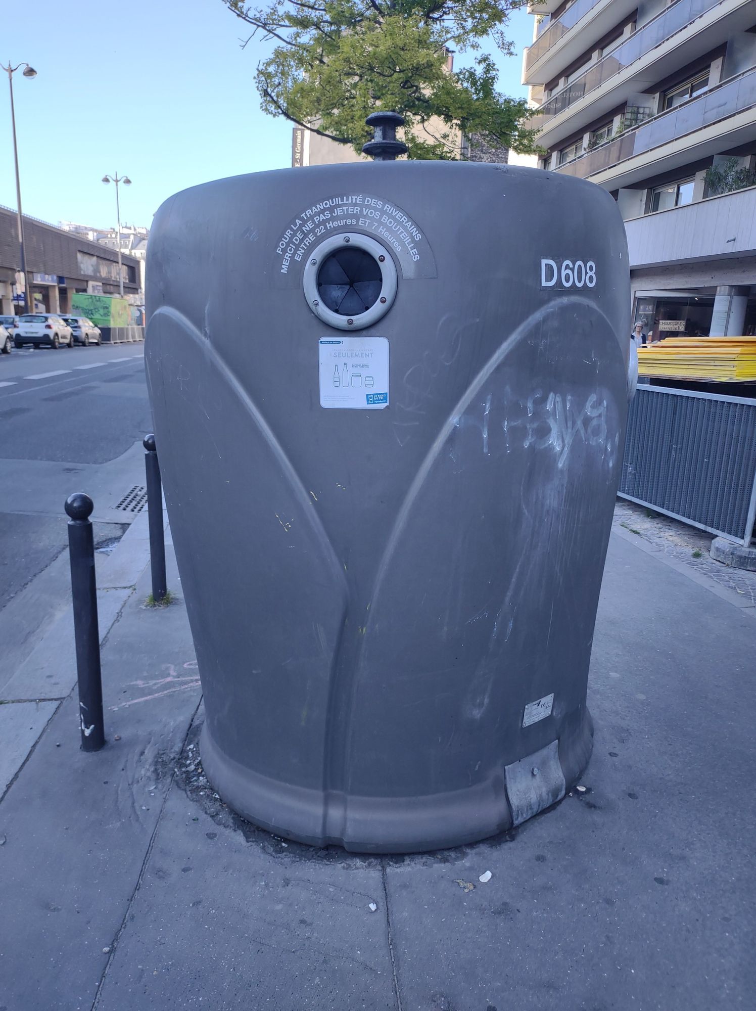 Large gray recycling bin for cans and bottles. 