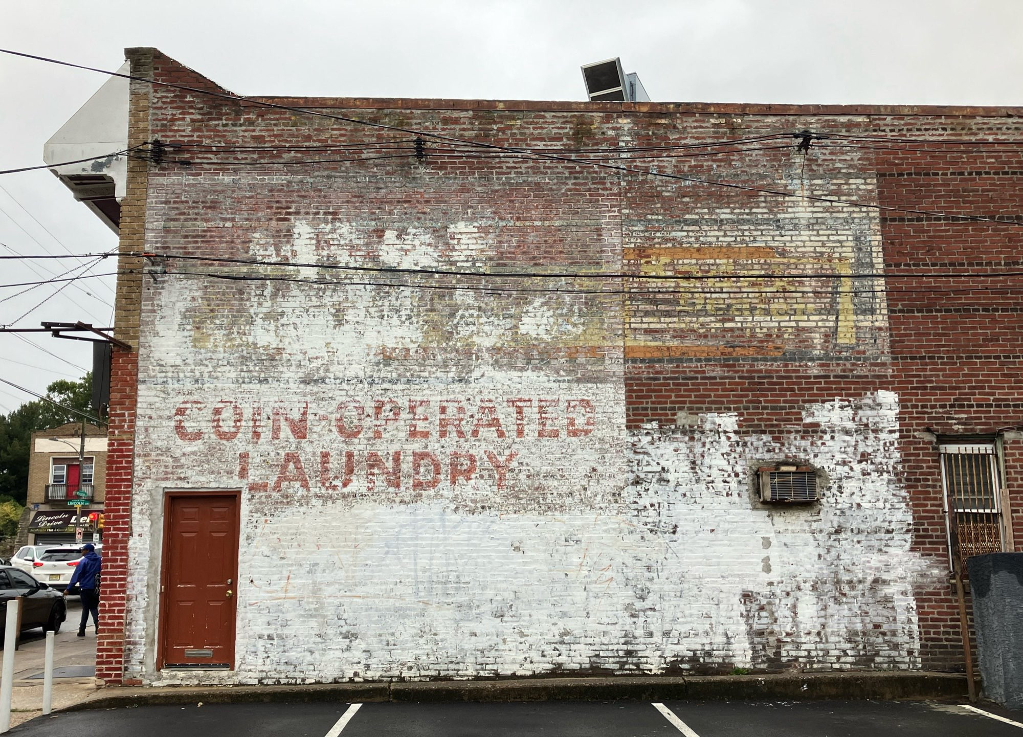 A wall with a faded sign that says “COIN OPERATED LAUNDRY” #ghostsign #philadelphia