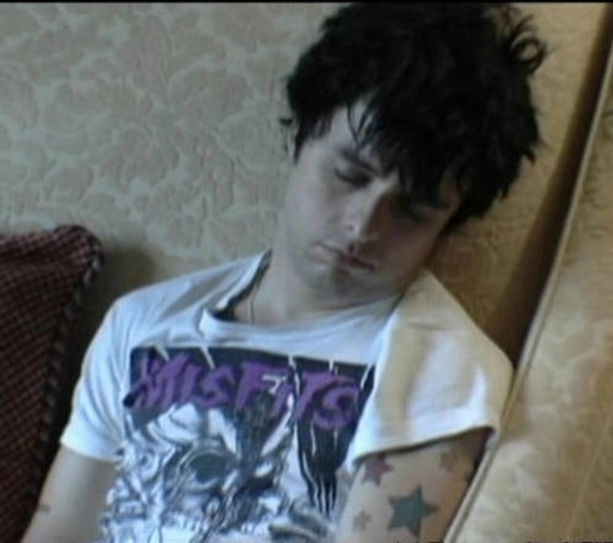 Billie Joe Armstrong, vocalista do Green Day, dormindo. Homem branco de cabelos pratos e camiseta branca.