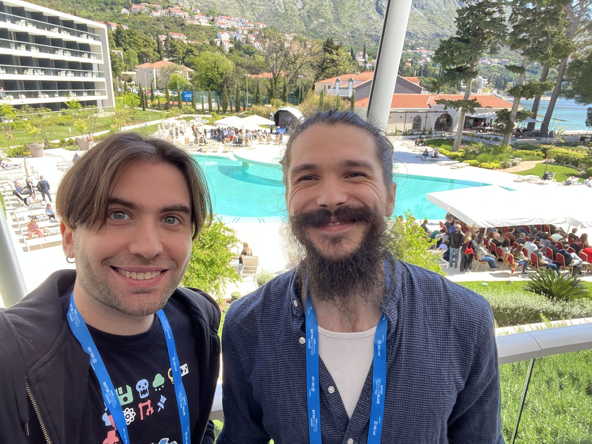 Emi and Krystof taking a selfie in front of the scenic conference grounds/pool area.