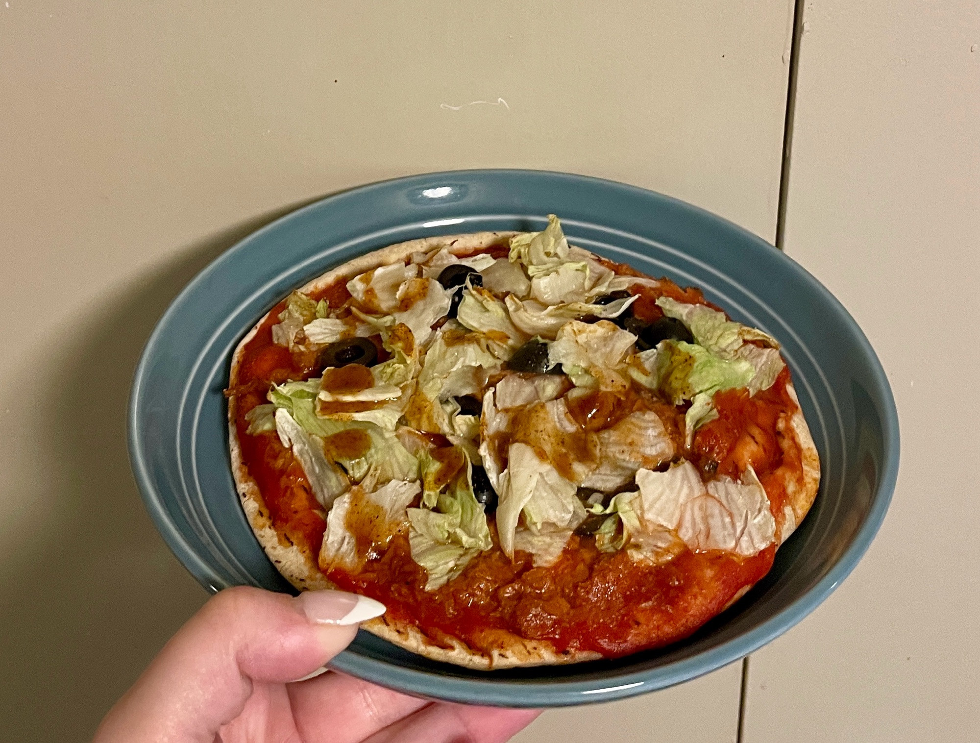 A blue plate being held up shows a “skinny pizza” which is 118 cal and is made of:
Pita bread- 60 cal
Tomato sauce- 20 cal
Veggie “meat”- 25 cal
Lettuce- 3cal
Olives- 10 cal
Taco Bell mild sauce- 1 packet