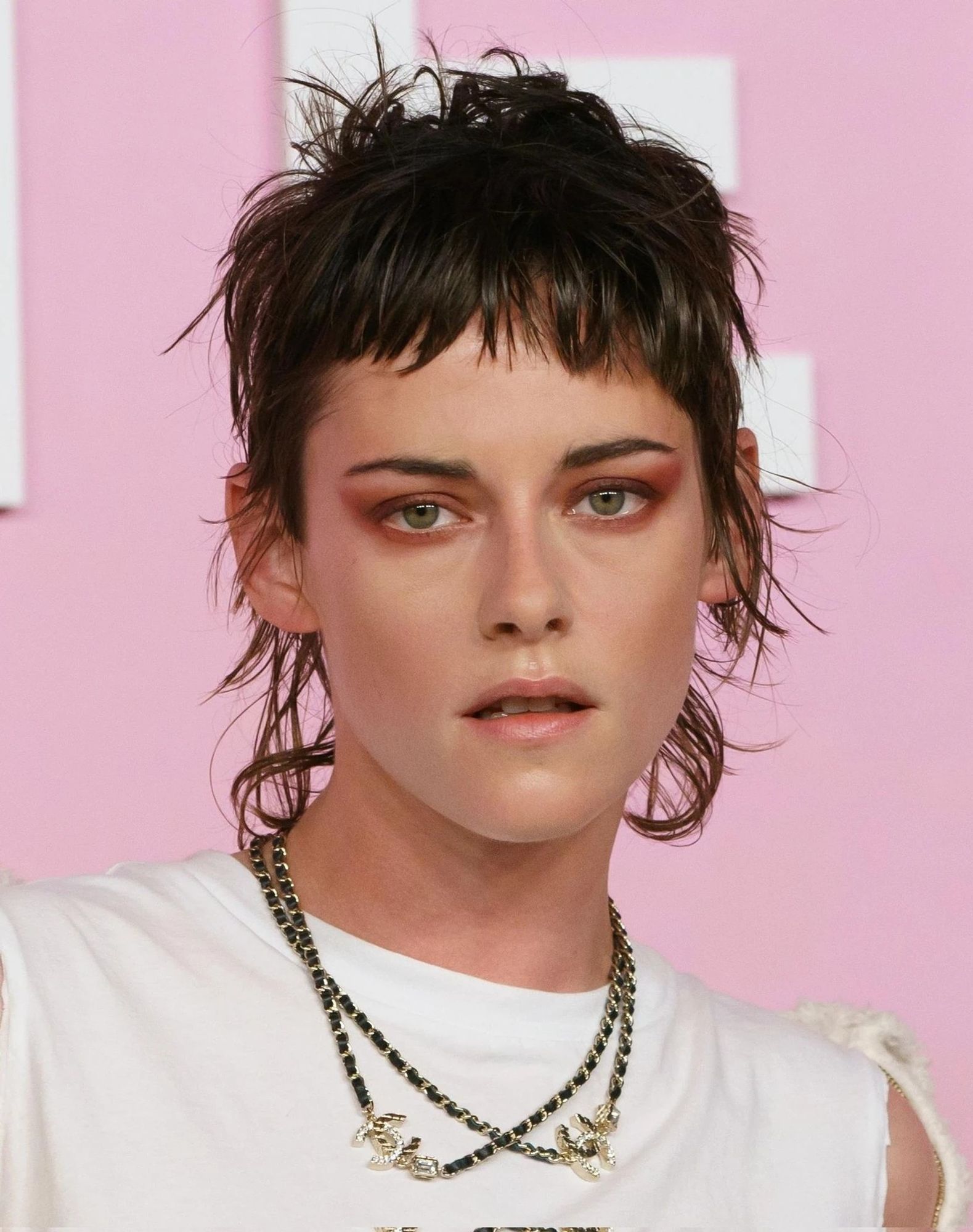 kristen with a disheveled fashion mullet, white top, red eye makeup, looking a little sweaty