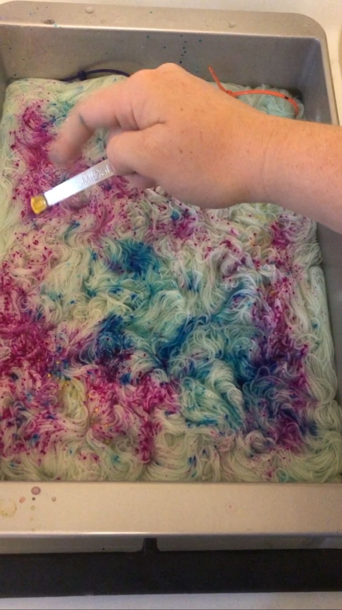 A picture of me sprinkling dye into the yarn.