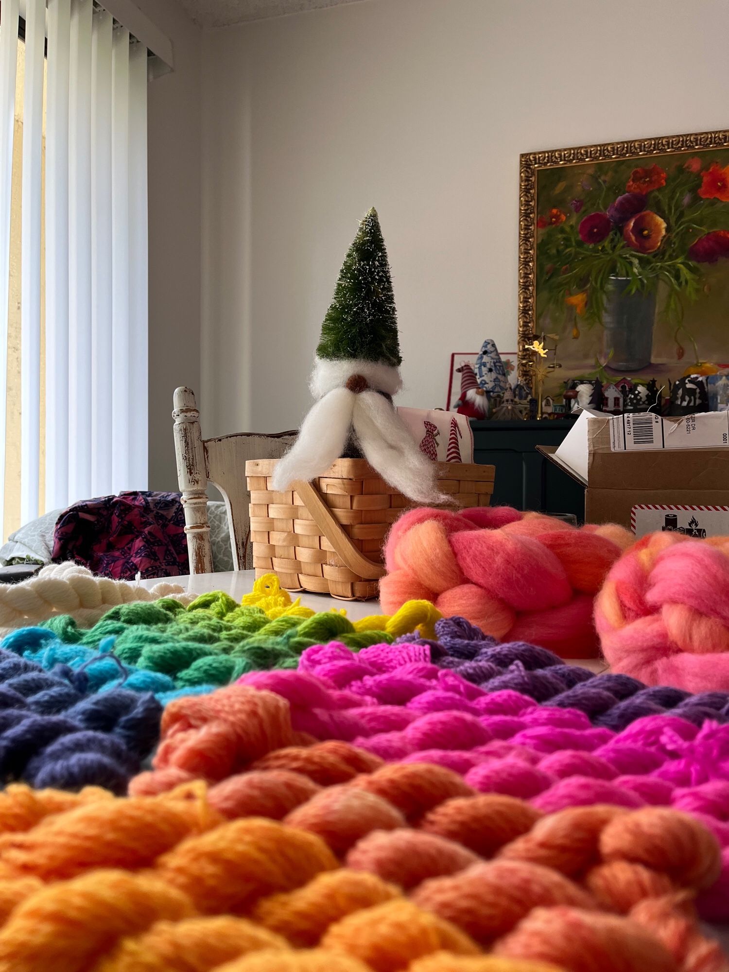 My yarn displayed in a colorful array with a felted gnome sitting atop a basket