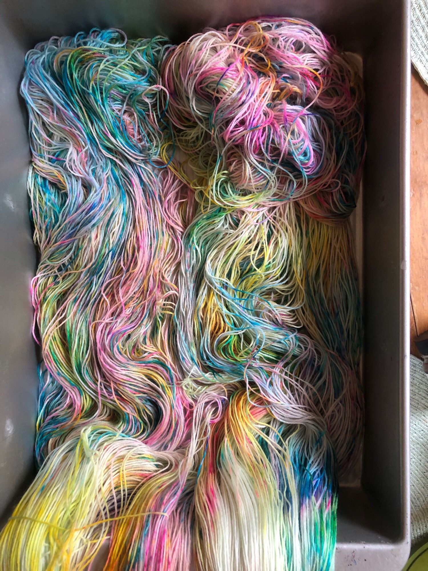 Rainbow yarn in the sun. The colors are blue and neon and yellow and pink!