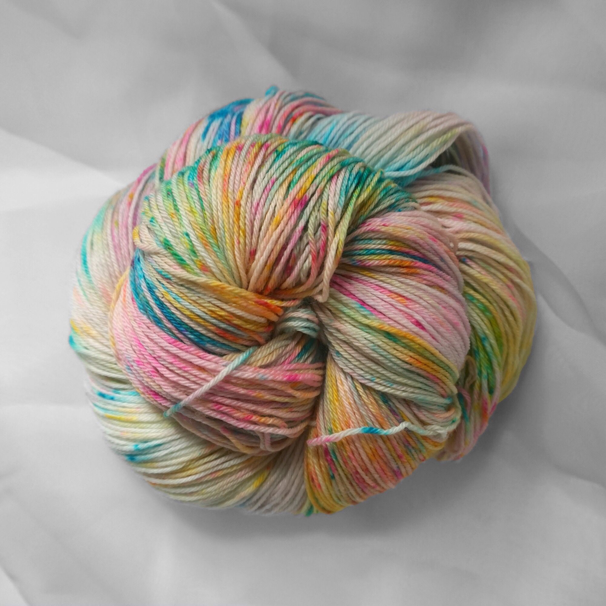 Yarn in a little bundle. The colors are splashes of pink and green and blue and yellow