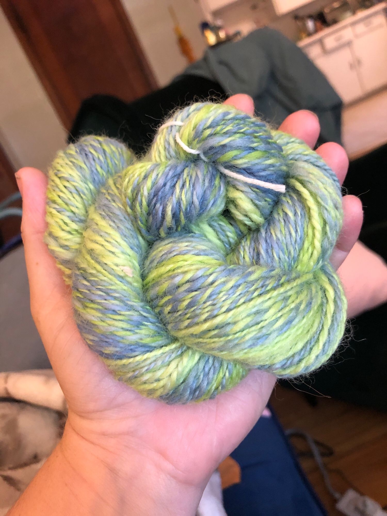 The same yarn held in my hand with better lighting ti show the colors