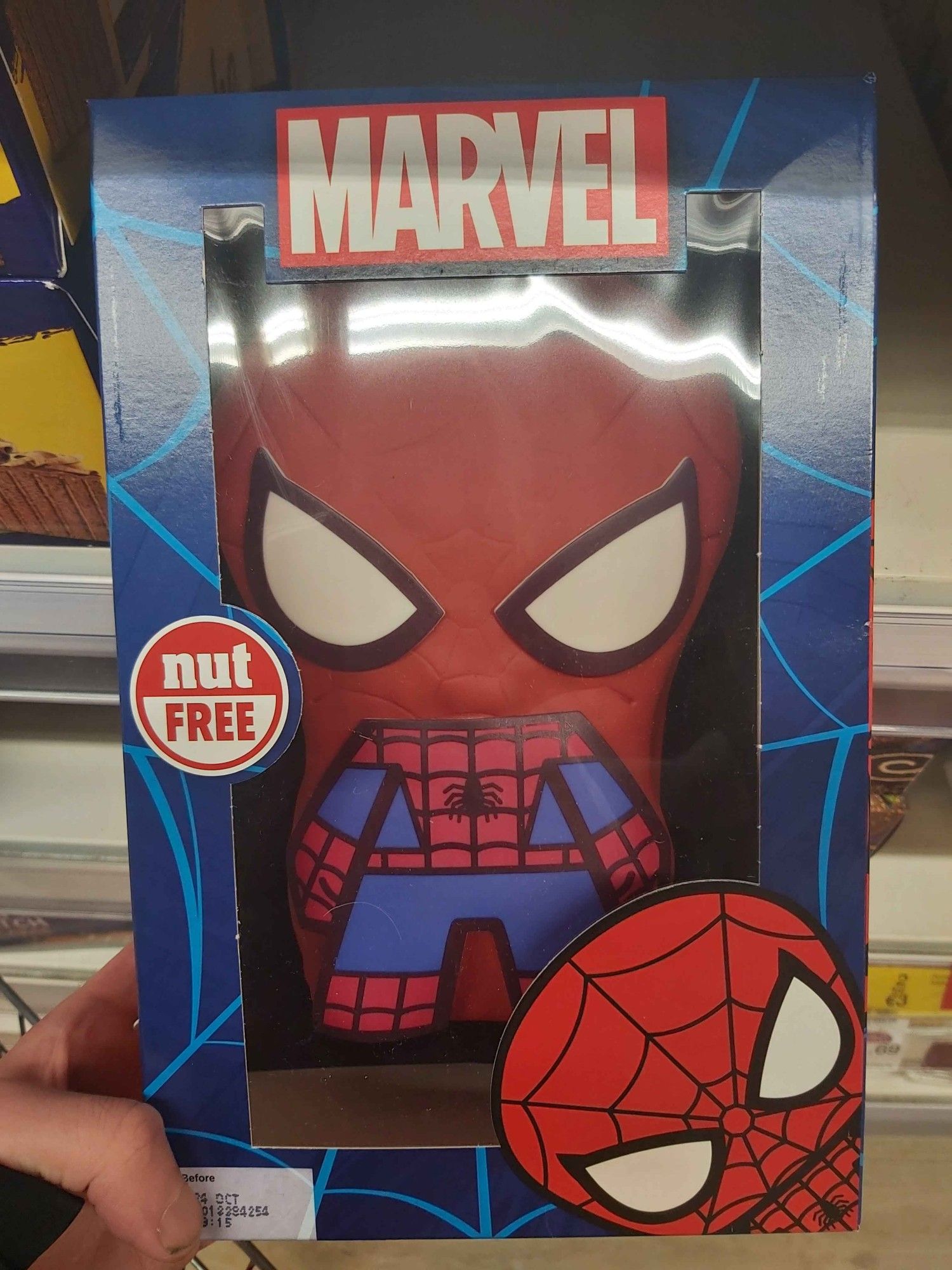 A weird chibi Spider-man birthday cake with a massive label reading "NUT FREE" on it