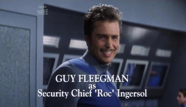 Still from Galaxy Quest with a freeze frame credits scene for the in-universe tv show with Guy Fleegman (Sam Rockwell) posing with a smile looking into the camera.

“GUY FLEEGMAN
as
Security Chief ‘Roc’ Ingersol”