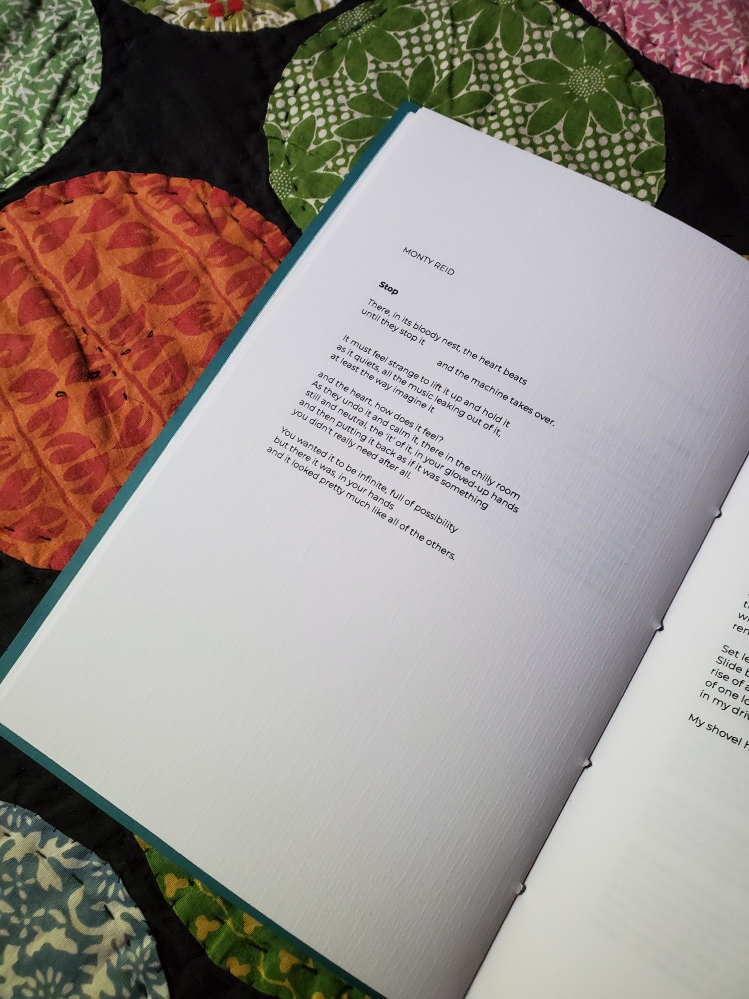 The poetry collection/chapbook Pinhole Poetry Volume Two Selected sits on a colourful quilt, open to a selected poem.