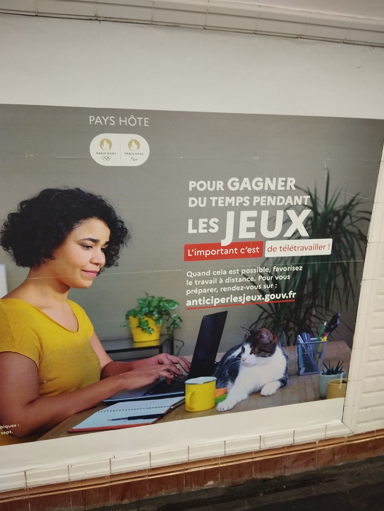 Publicité dans le métro pour les JO avec écrit "Pour gagner du temps pendant les jeux, l'important c'est de télétravailler ! Quand cela est possible, favorisez le travail à distance. Pour vous préparer, rendez vous sur : anticiper les jeux point gouv point fr"