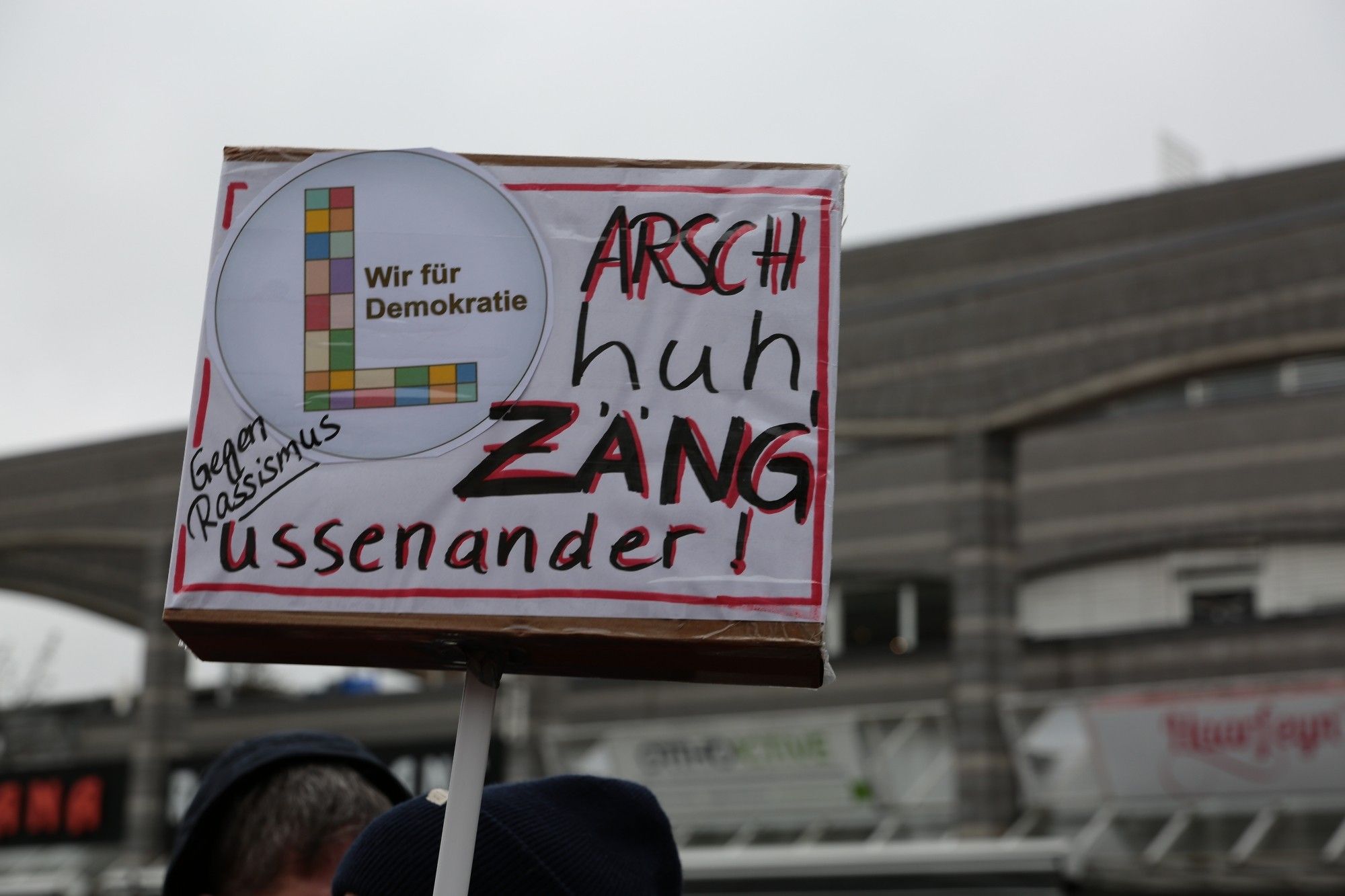 Schild "Arsch huhu, Zäng ussenander!"