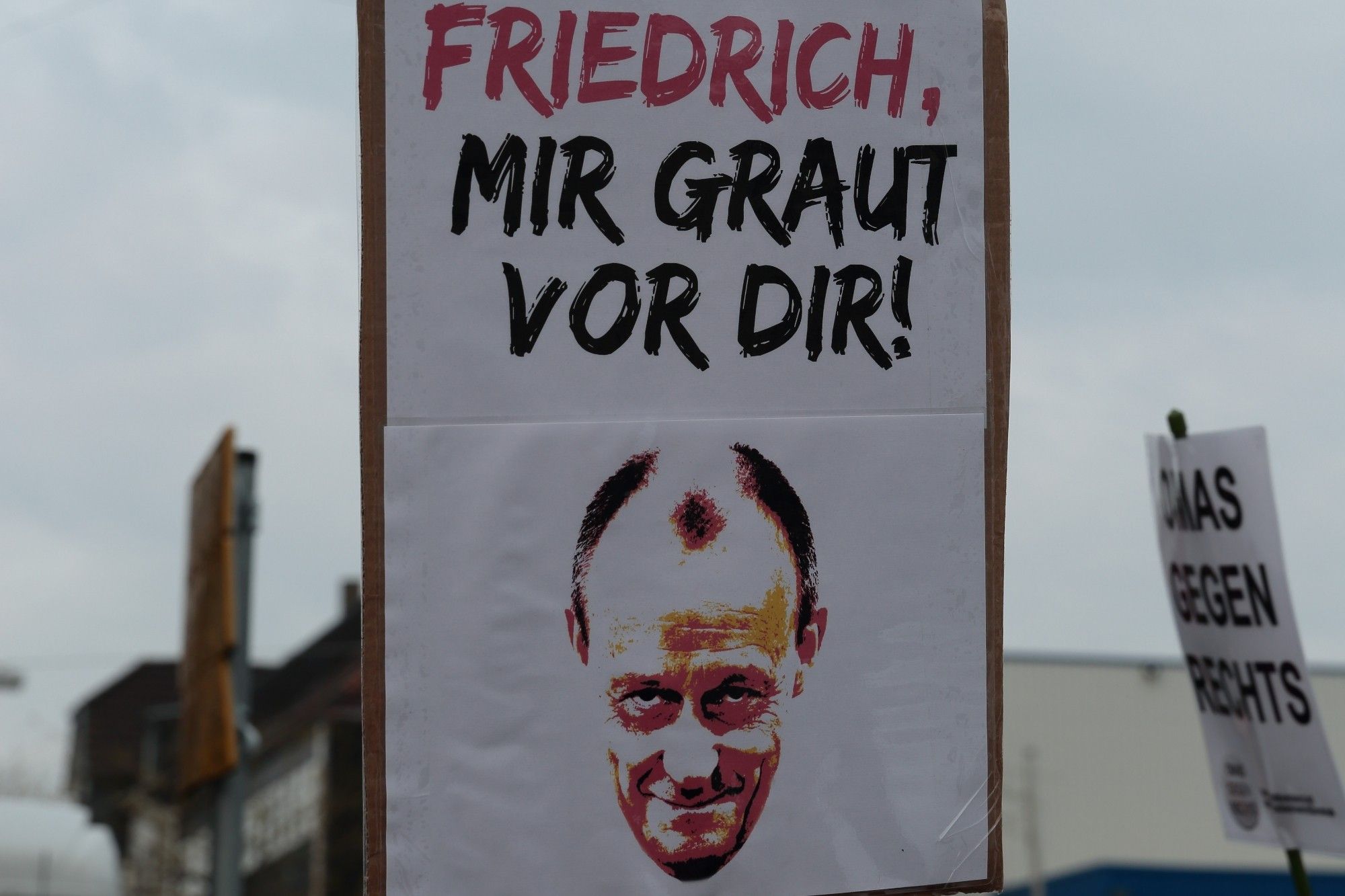 Schild mit dem Text "Friedrich, mir graut vor dir!" und einem unvorteilhaften Bild von Merz