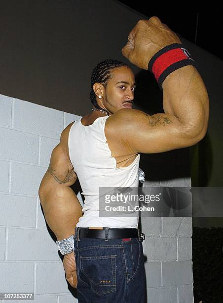 Ludacris flexing while wearing his giant arm prosthetics