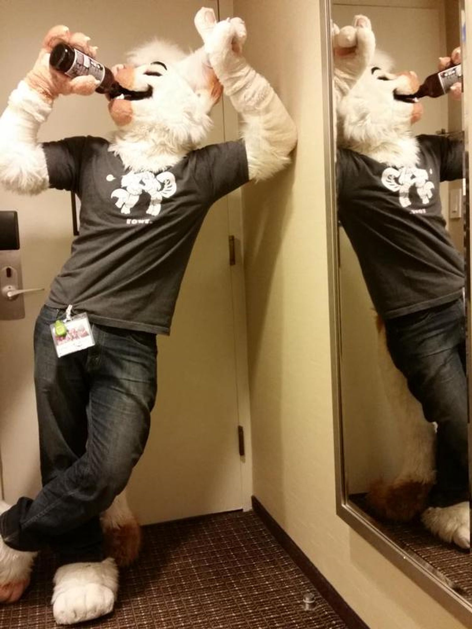 Photo of me wearing my partial Smudge fursuit while attending Furfright 2013.  I'm just inside a hotel room past the closed door, leaning with one arm against the wall, drinking from a 22 ounce beer bottle thanks to the fursuit head's moveable jaw.  I may not remember who's hotel room I am in, but I can say with 100% certainty that what I'm drinking is a JK's Farmhouse Scrumpy hard cider.