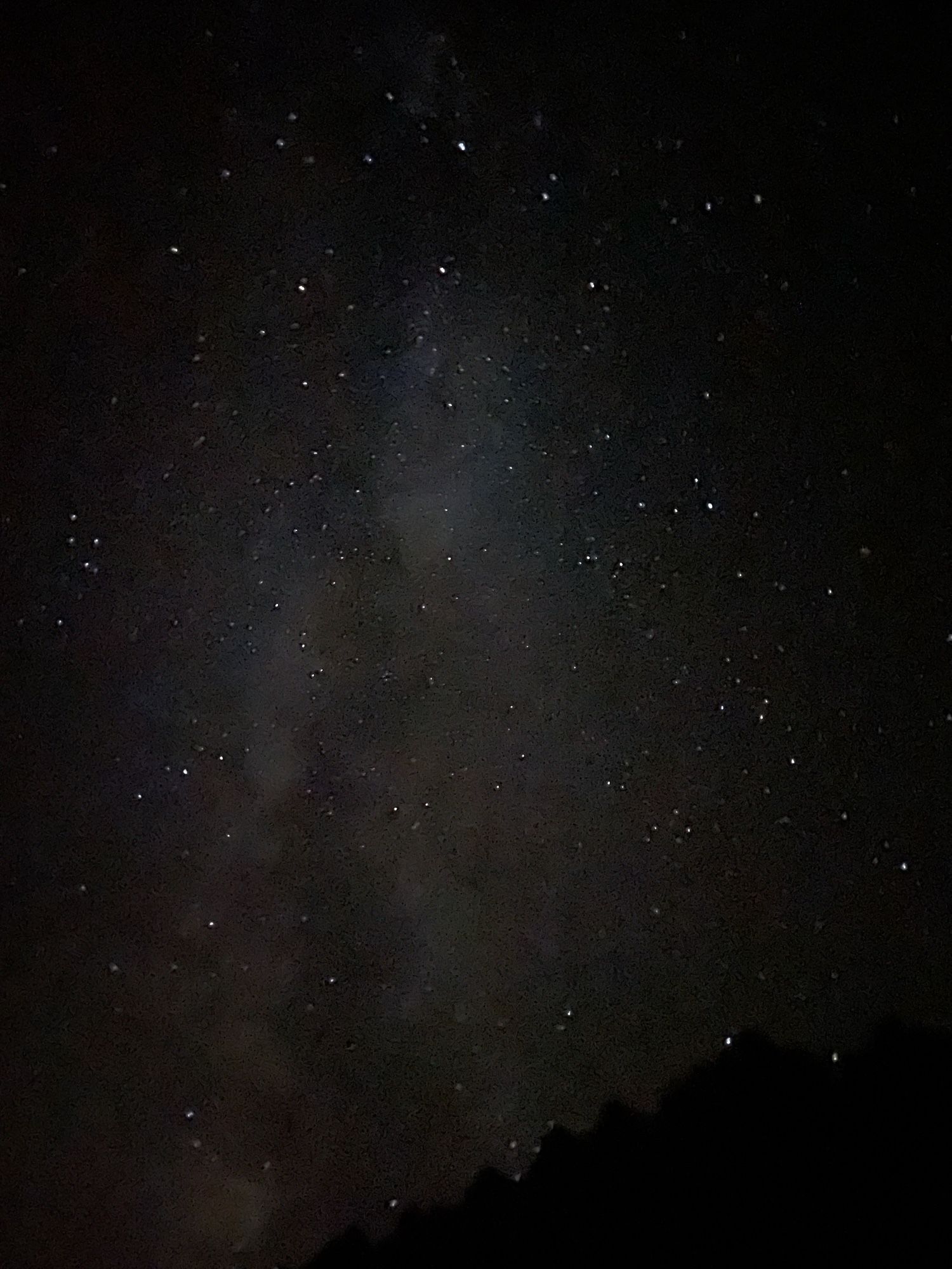 Bright cluster of clouds looking high, due Southwest, with whisps of milky gas moving along the latitude. Stars as far as the eye can see.