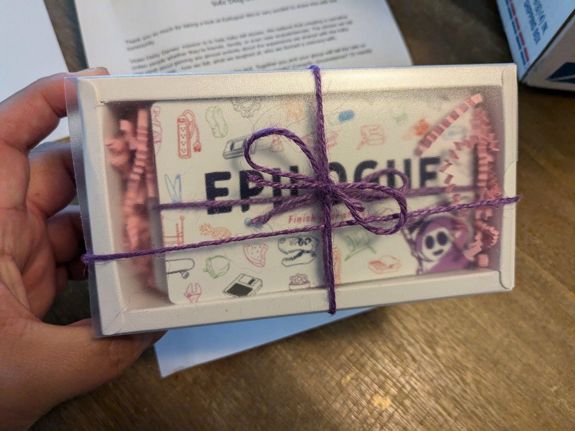 A hand-tied package containing the storytelling game Epilogue by Violet Daisy Games.