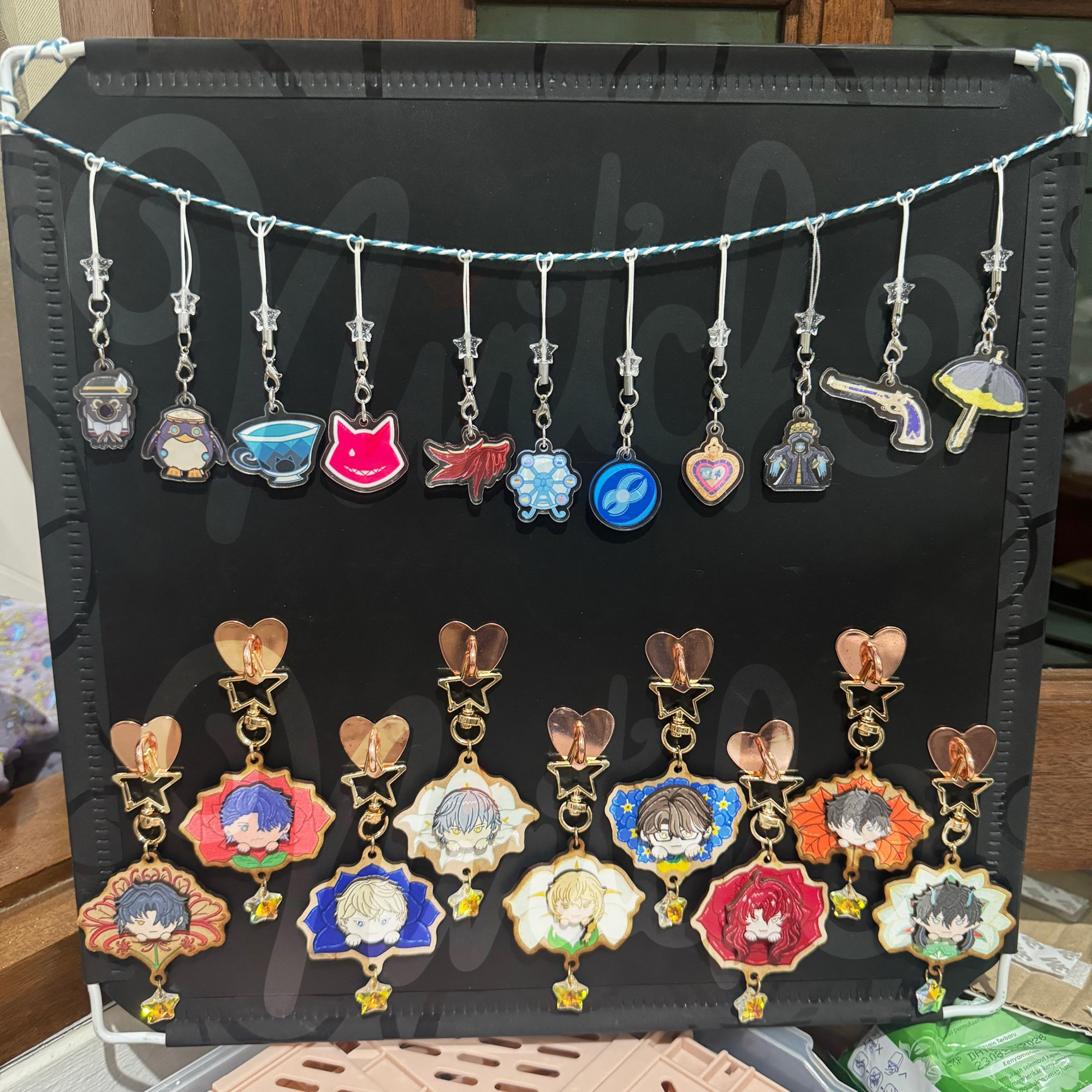 **On Top:** Fontaine Icon Charm Phonestrap  
From left to right:  
- Charlotte  
- Freminet  
- Lynette  
- Lyney  
- Arlecchino  
- Furina  
- Neuvilette  
- Sigewinne  
- Wriothesley  
- Clorinde  
- Navia  

---

**Below:** Flower Over Boys: Honkai Star Rail Edition Wooden Keychain  
From left to right:  
- Blade  
- Sampo  
- Gepard  
- Caelus  
- Luocha  
- Welt  
- Argenti  
- Dan Heng  
- Dan Heng (Imbibitor Lunae)