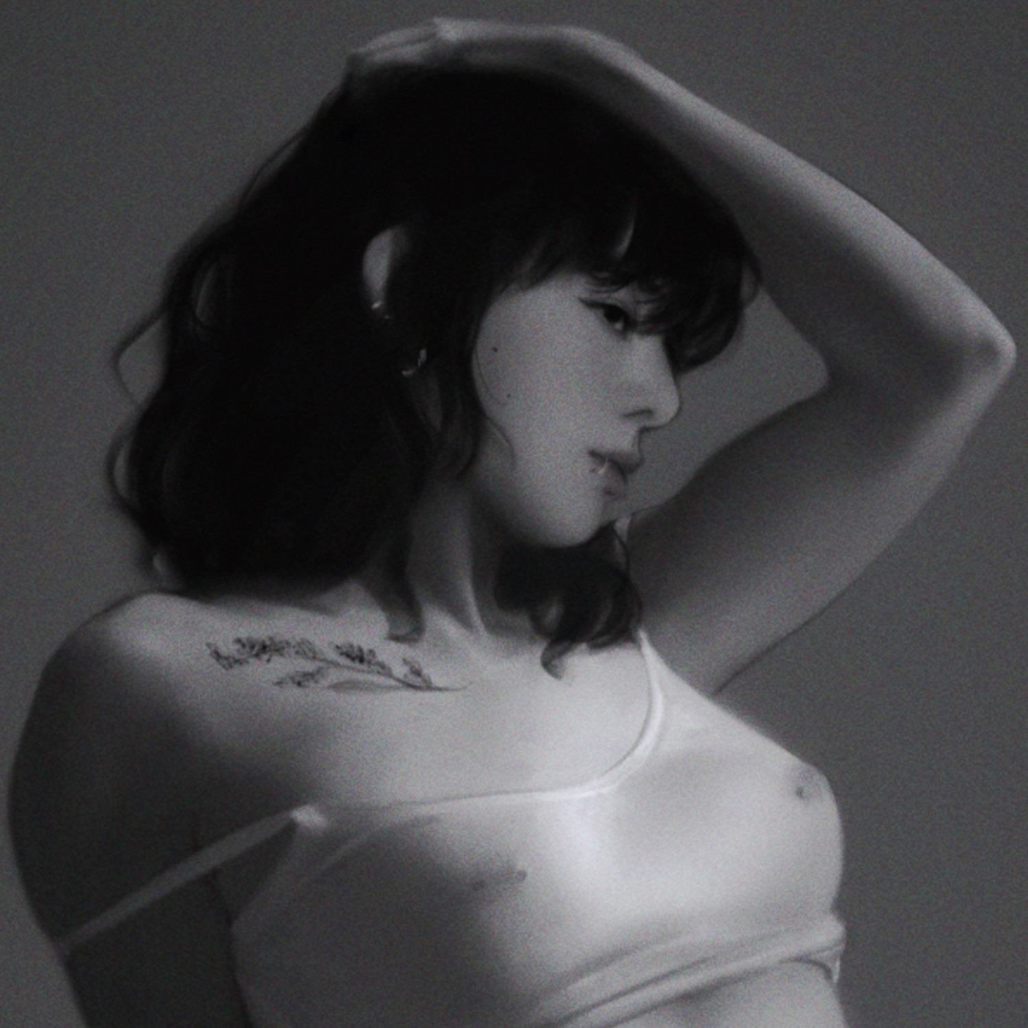 crop of a black and white illustration of jungha. the strap of her camisole falls off her right shoulder as she poses with the opposite arm above her head.