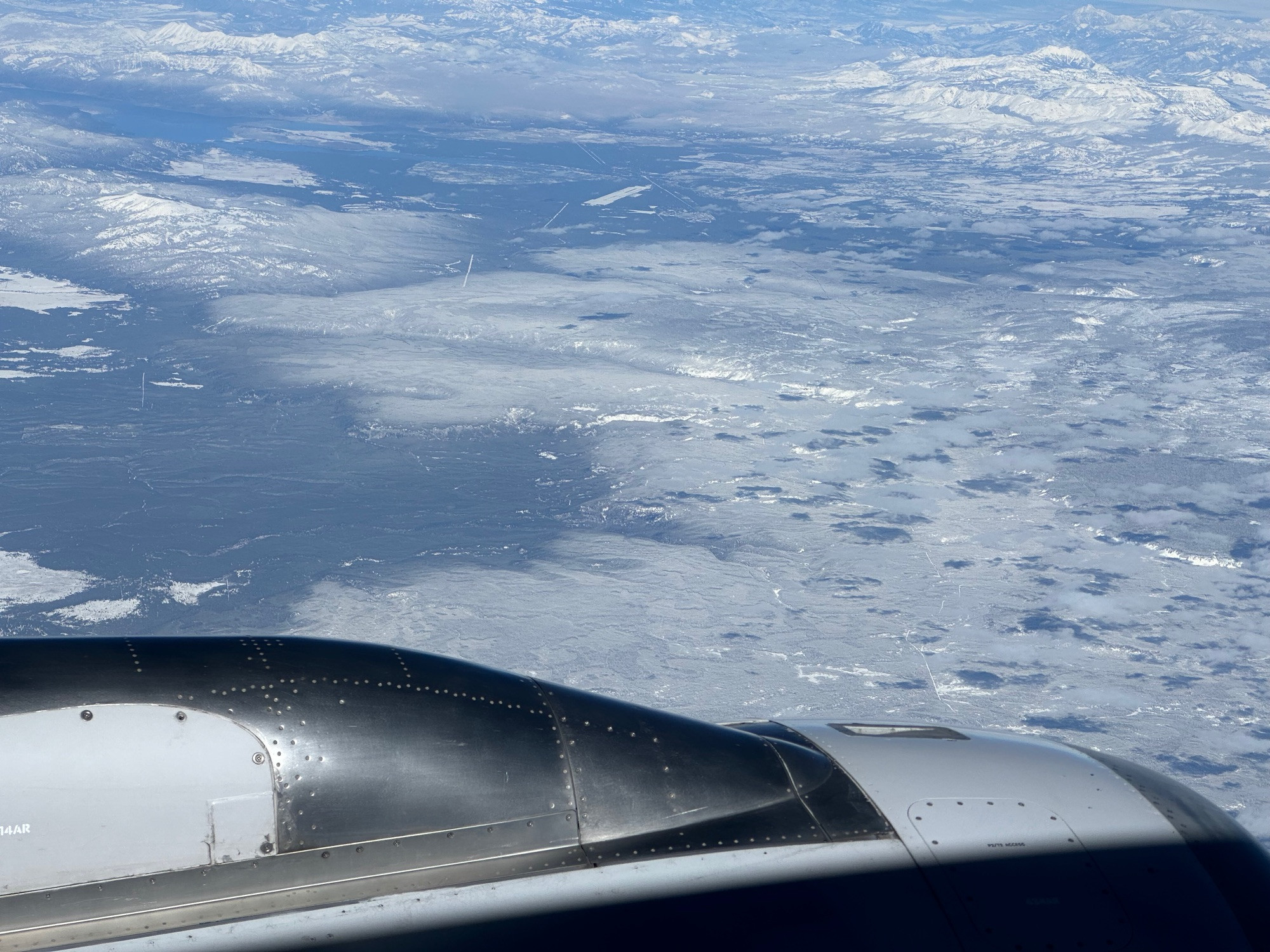 As seen from an airplane window, a recent snow covers forest canopy in the Yellowstone region.