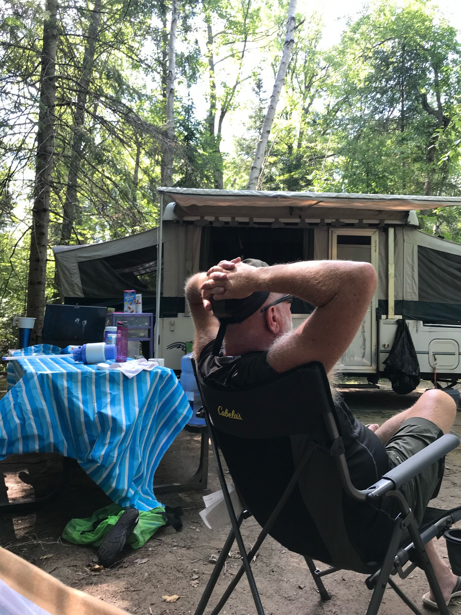 Camping with our old 96 Coleman pop up/tent trailer. Hubs in the foreground on a camp chair