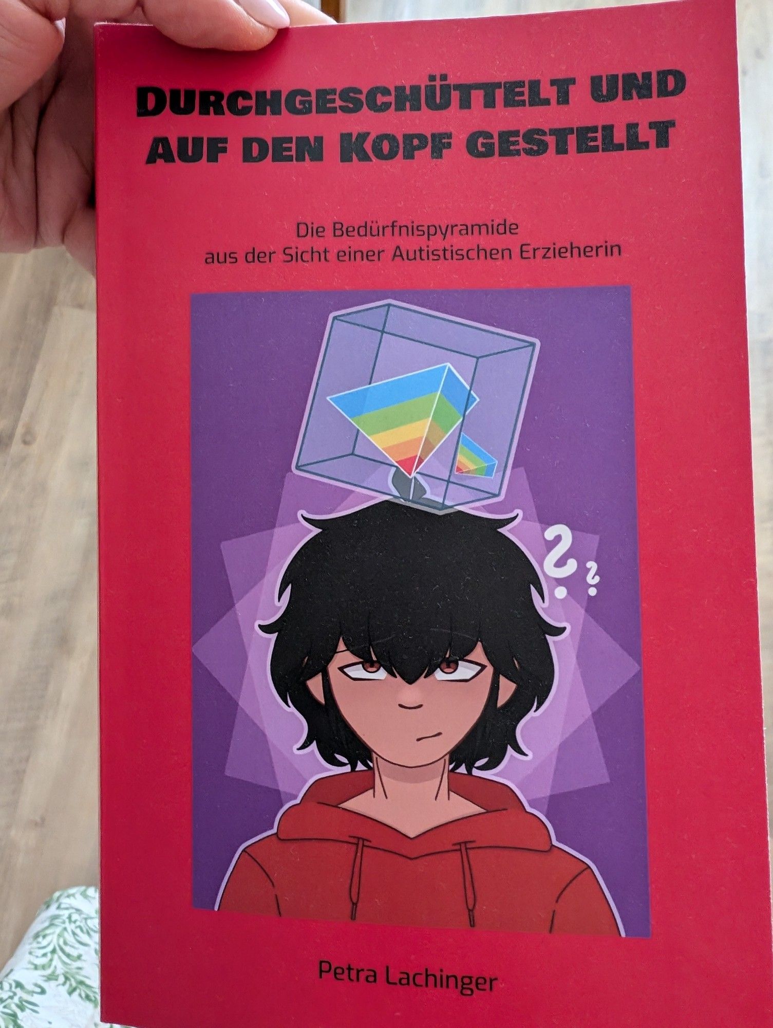 Ein rotes Buch. 
Titel "Durchgeschüttelt und auf den Kopf gestellt" von Petra Lachinger