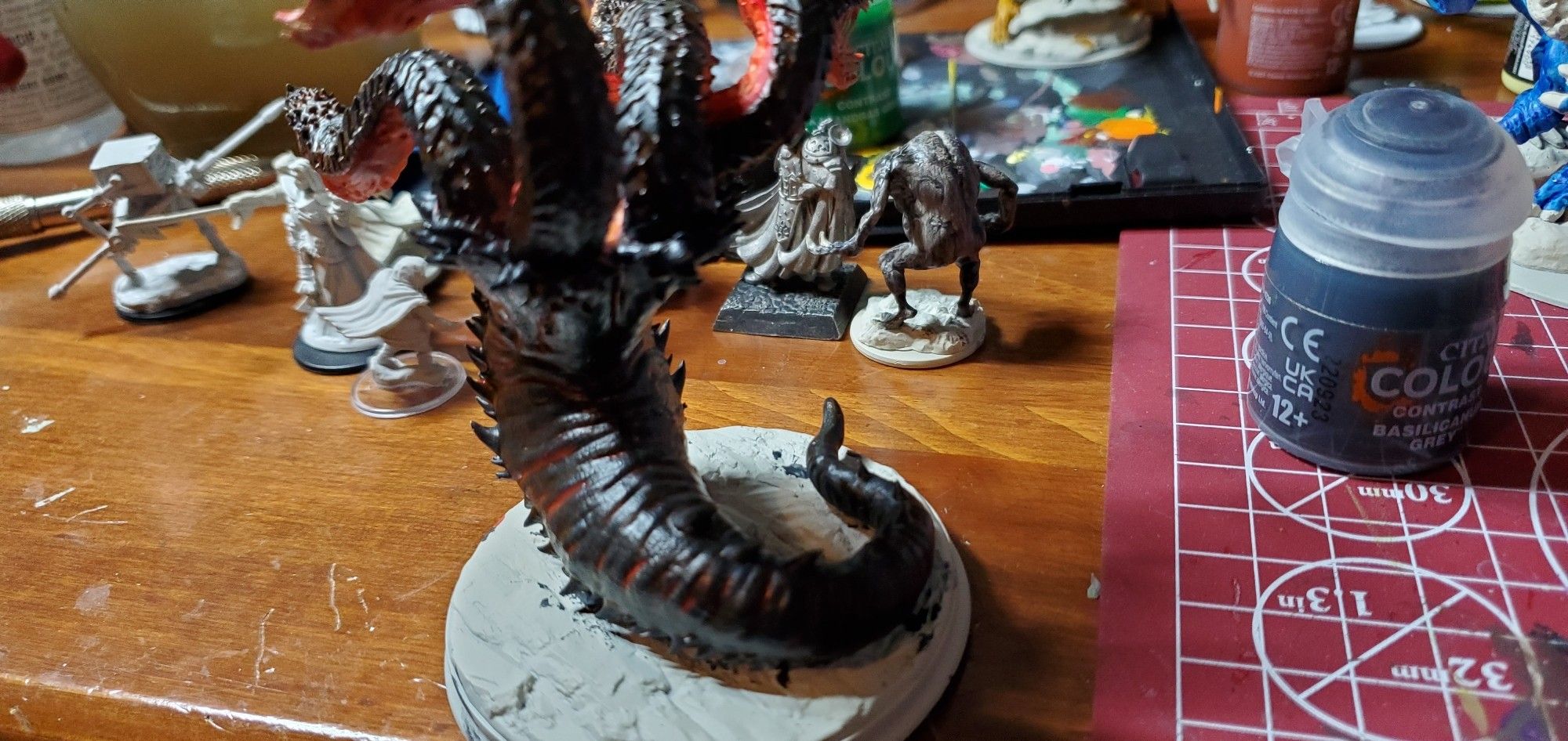 Picture of my painted model Hydra, printed in resin and colored to look like it's crawled out of a volcano. More half painted models behind it.