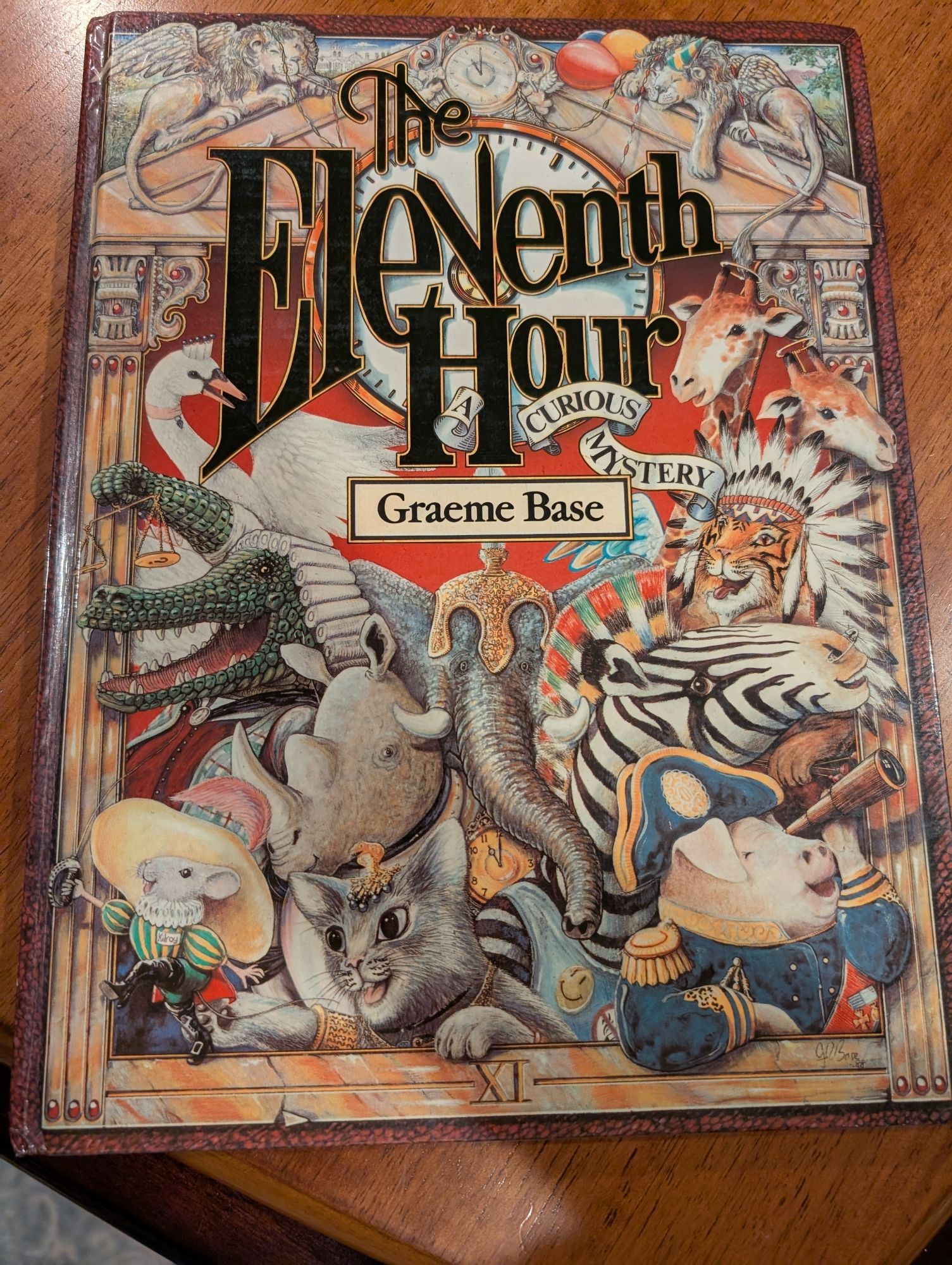 The front cover of The Eleventh Hour by Graeme Base. It's covered with animals dressed in costumes because they are going to a fancy party.