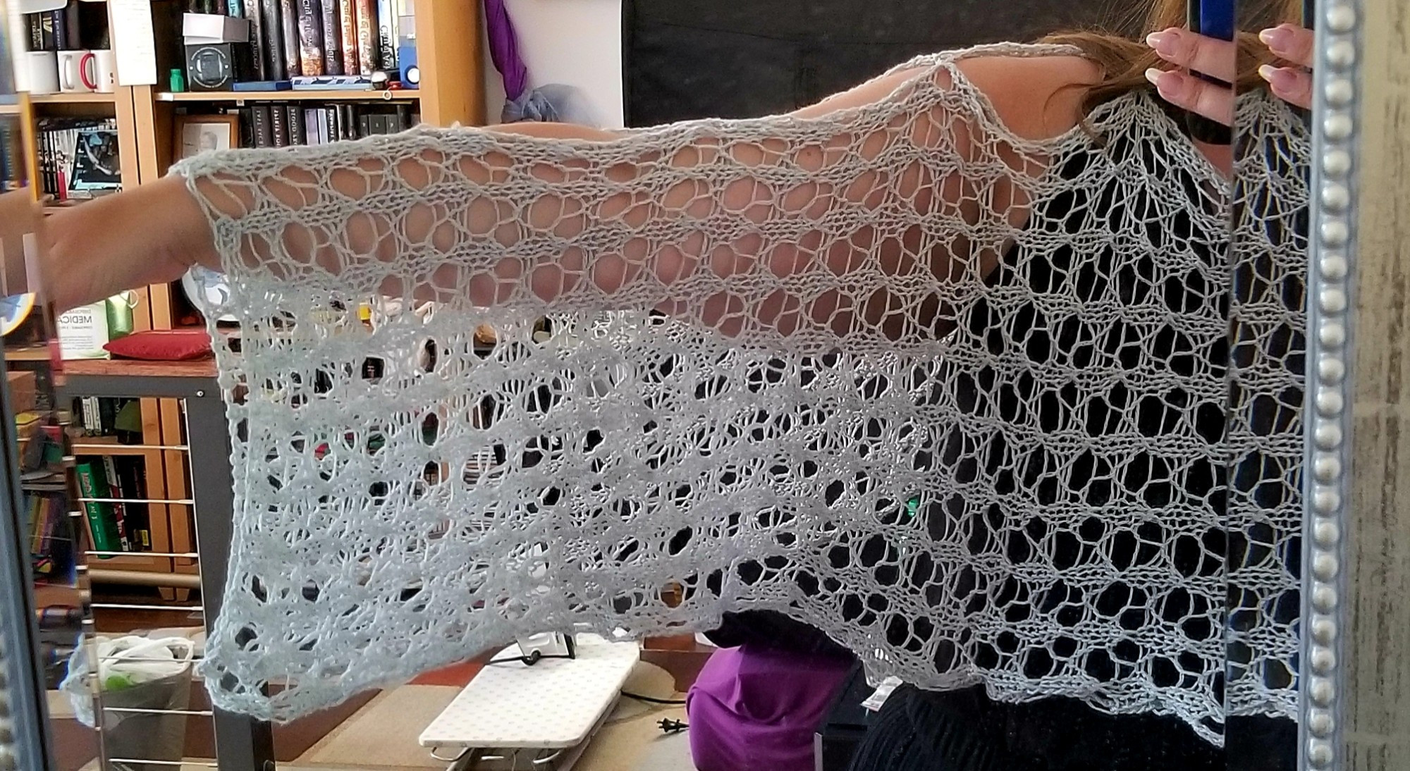 A light grey lace shawl. Photo shows the arm-length sleeve