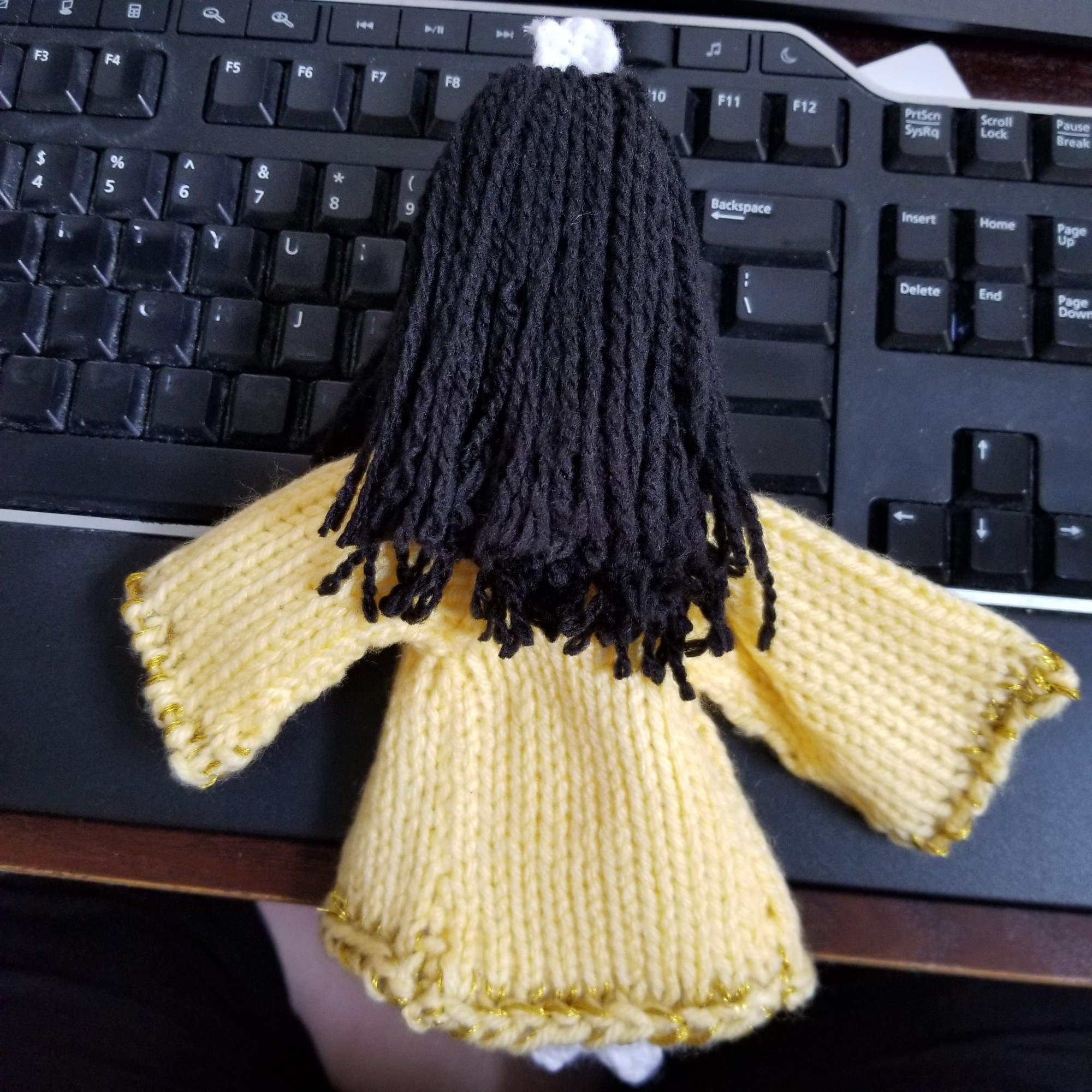 Back view of the Feng Xiao doll, showing his long black hair and light yellow outer robe with gold trim.