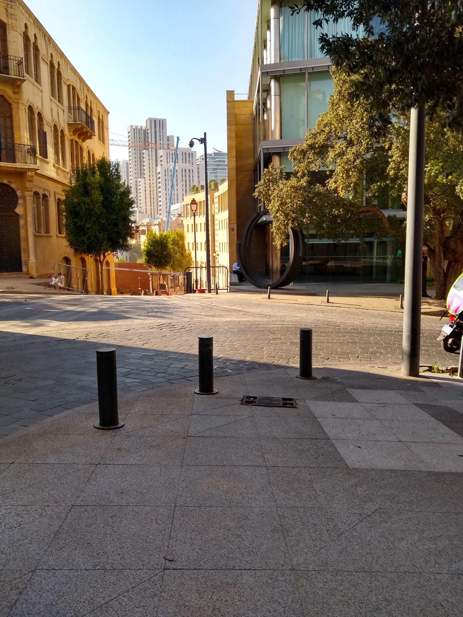 beautiful golden hour light on a street with traditional architecture on one side and glass office buildings on the other and construction in the distance