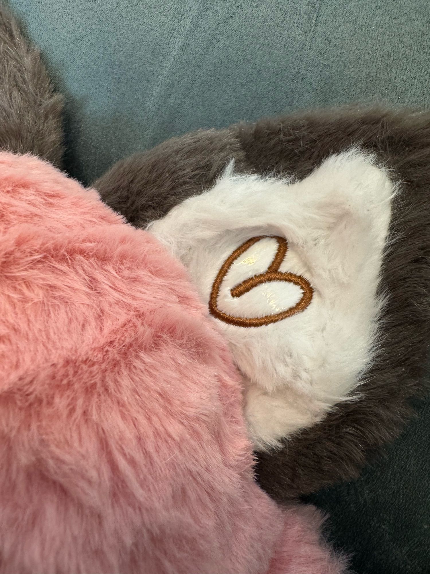 Close-up of the inside of the plush fox’s ear with cute brown heart embroidery detail showing that the clear plastic embroidery topper/stabilizer inside the heart is still in place.