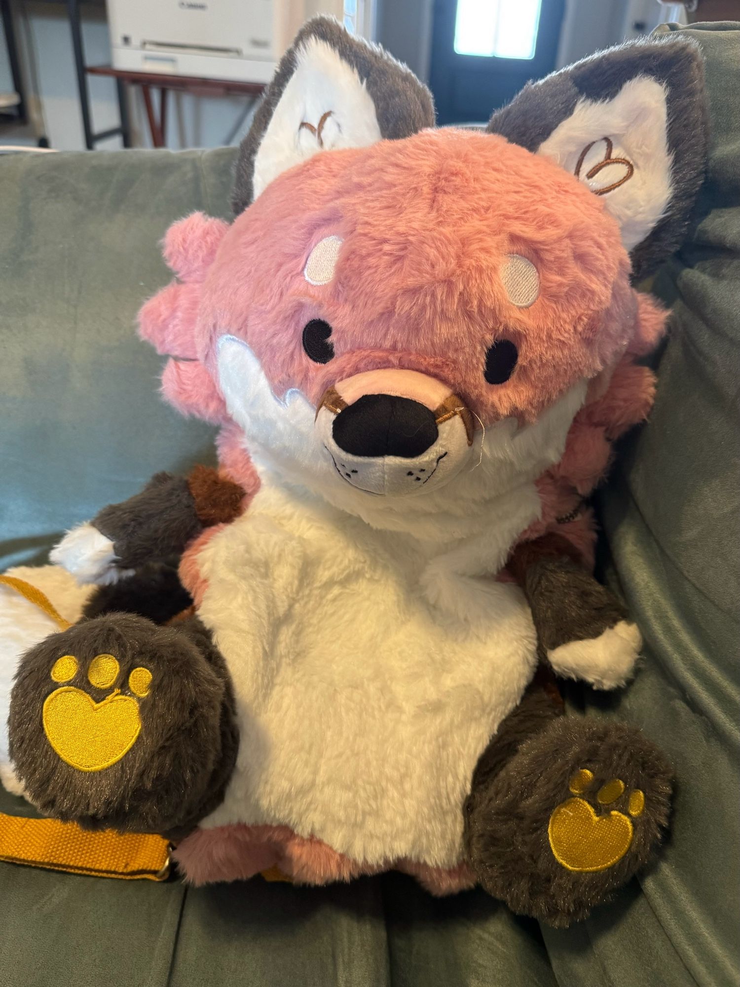 Photo of a “Snug-Alongs” plush fox backpack by LittleSofts, a 15” tall fluffy salmon-colored fox with a cute face and embroidered details.