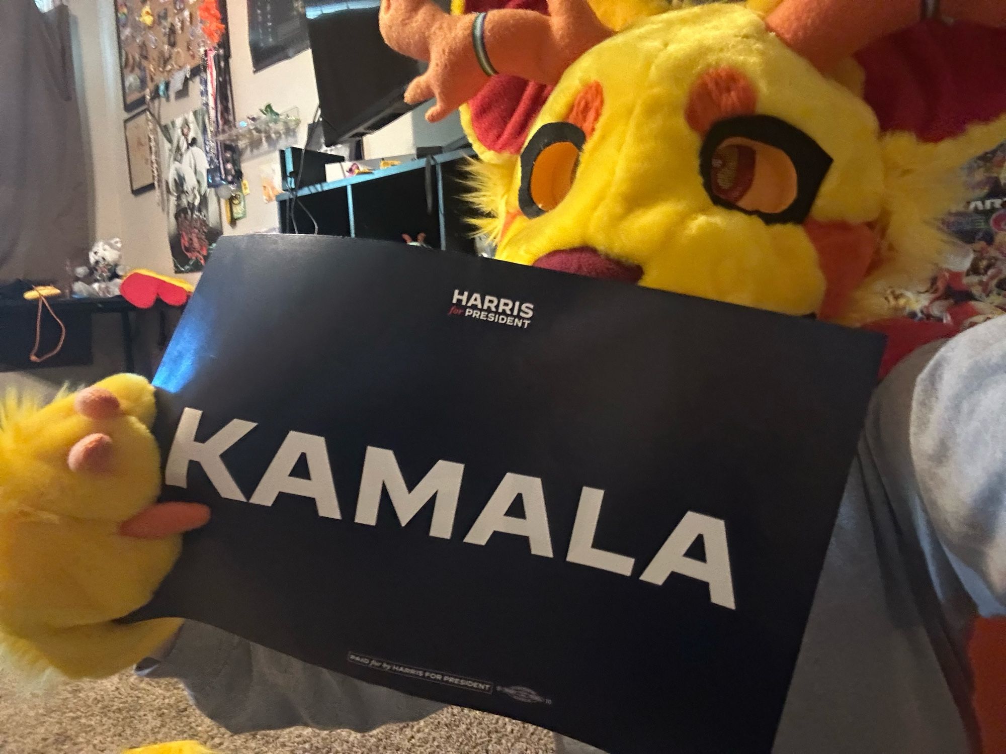 Me in my fursuit holding up a Kamala sign