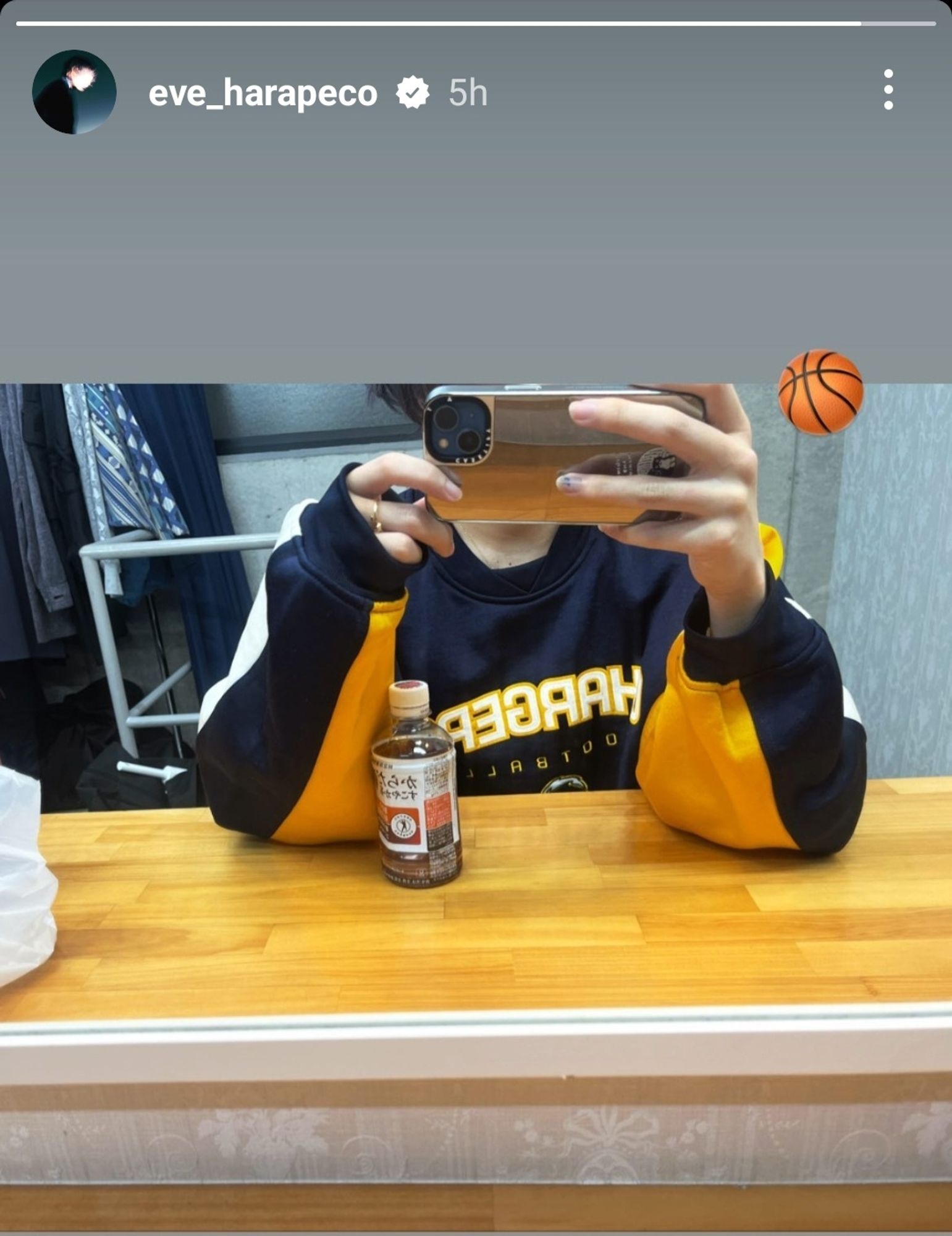 screenshot of harapeco_eve instagram story where he is wearing a dark blue football long-sleeve shirt with orange and white sleeve stripes. He added a basketball emoji.