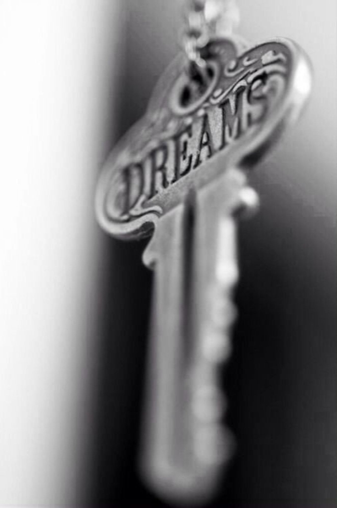 Photo noir et blanc d'une clef sur laquelle est inscrit "Dreams".