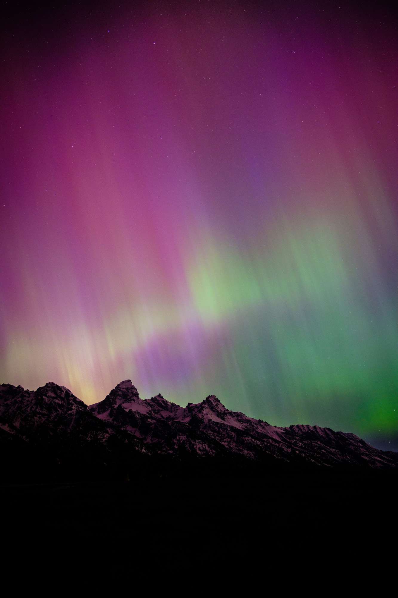 The Teton Range, seen at night under the Aurora Borealis.