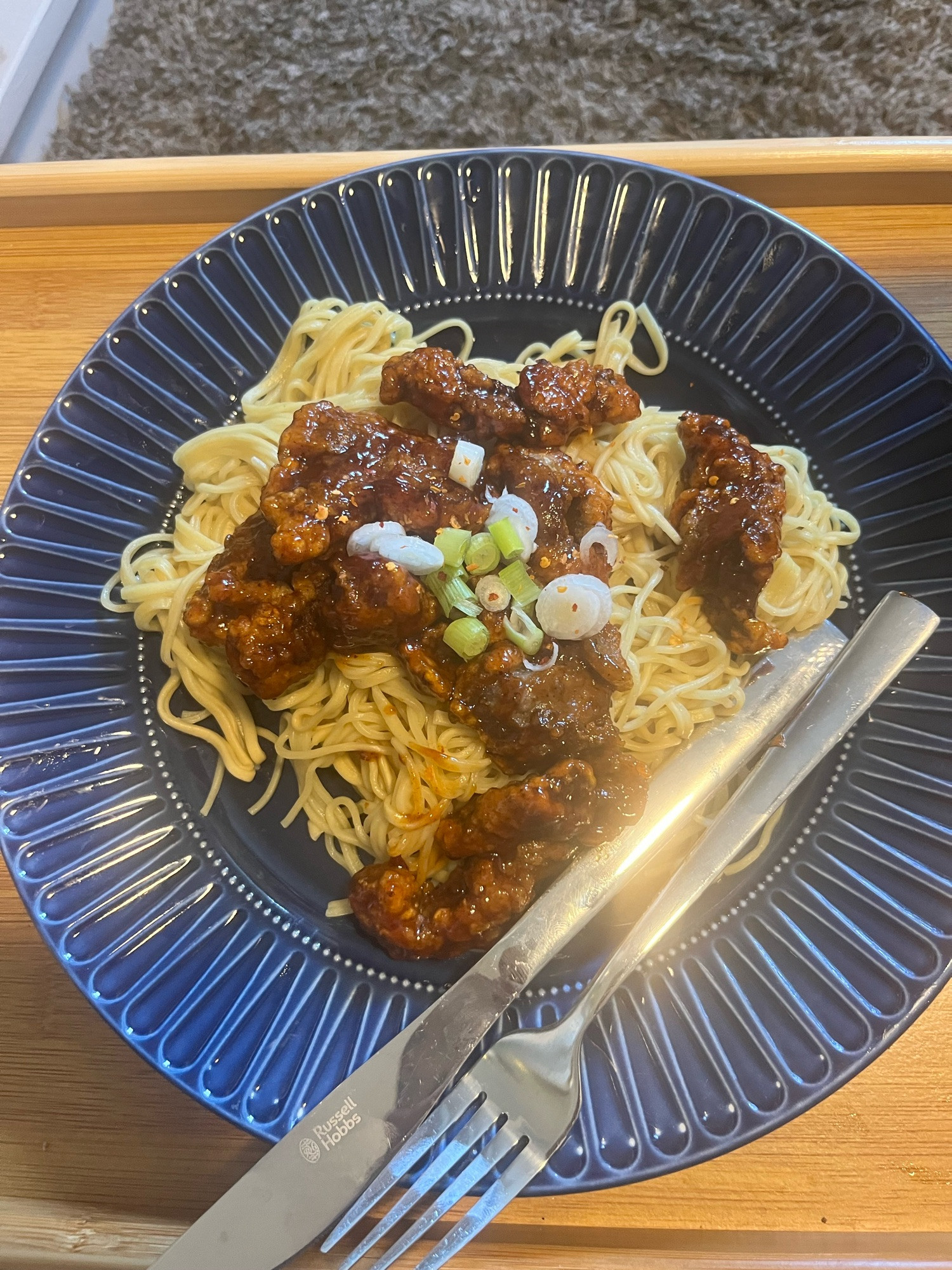 crispy beef in a sweet chili glaze over noodles