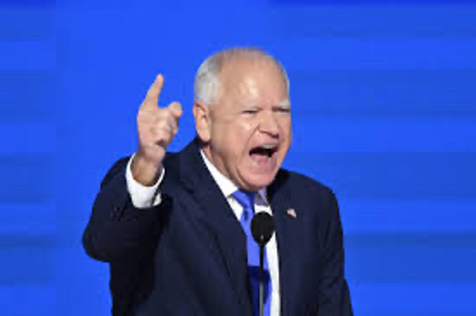 Walz in suit and tie speaking with a pointed finger raised