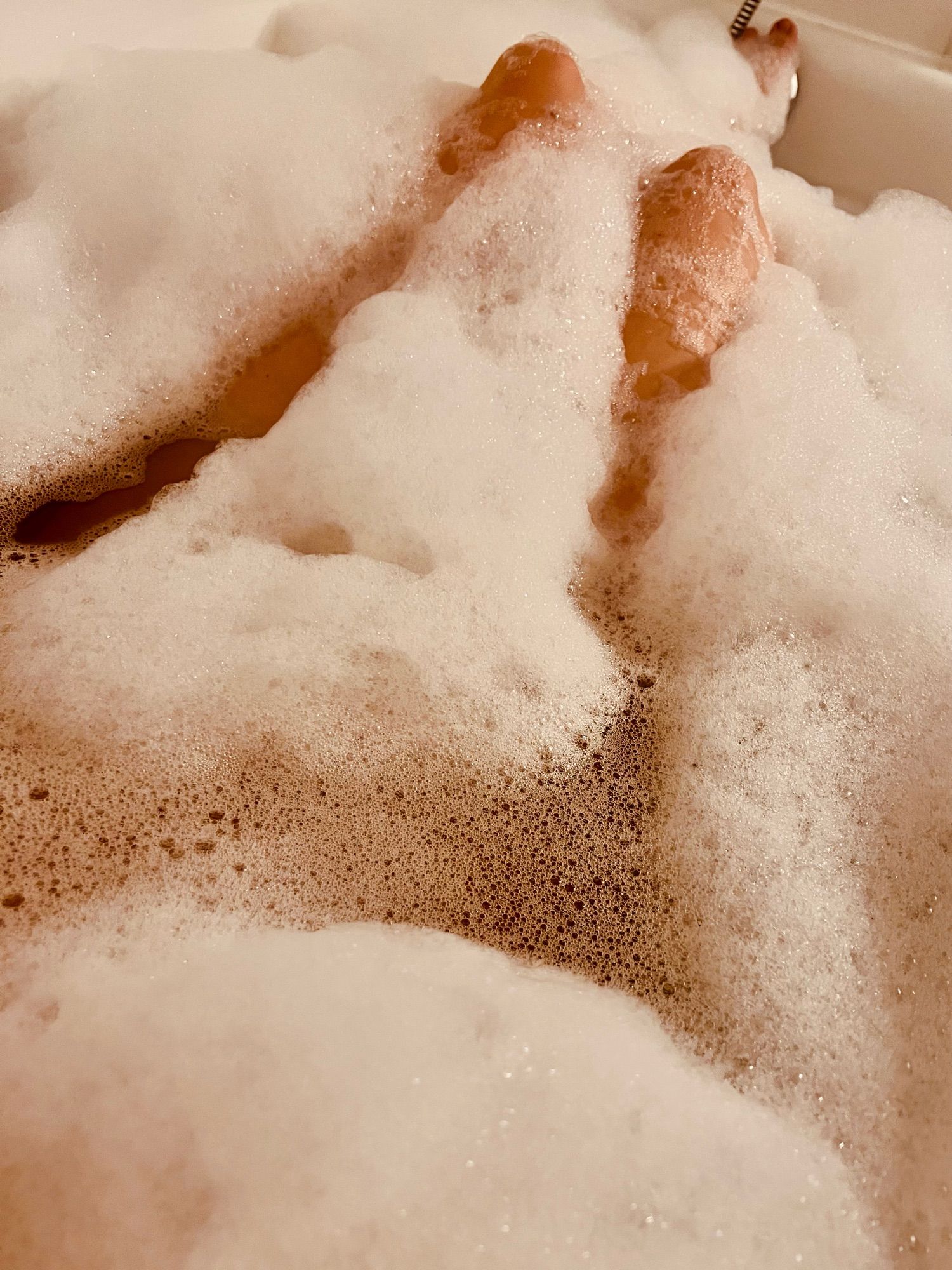 Ein Foto von meinen Beinen in der Badewanne und sehr viel Schaum.