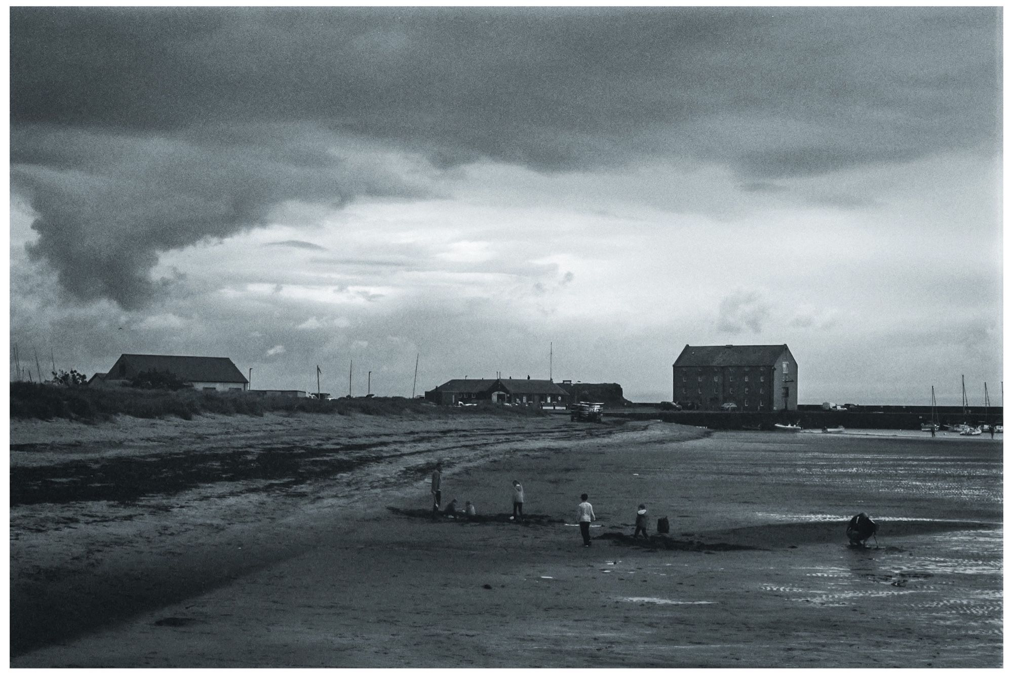 A dark and overcast day at Elie beach on the east coast of Scotland. The sky threatened rain but it did not stop the family playing on the beach.