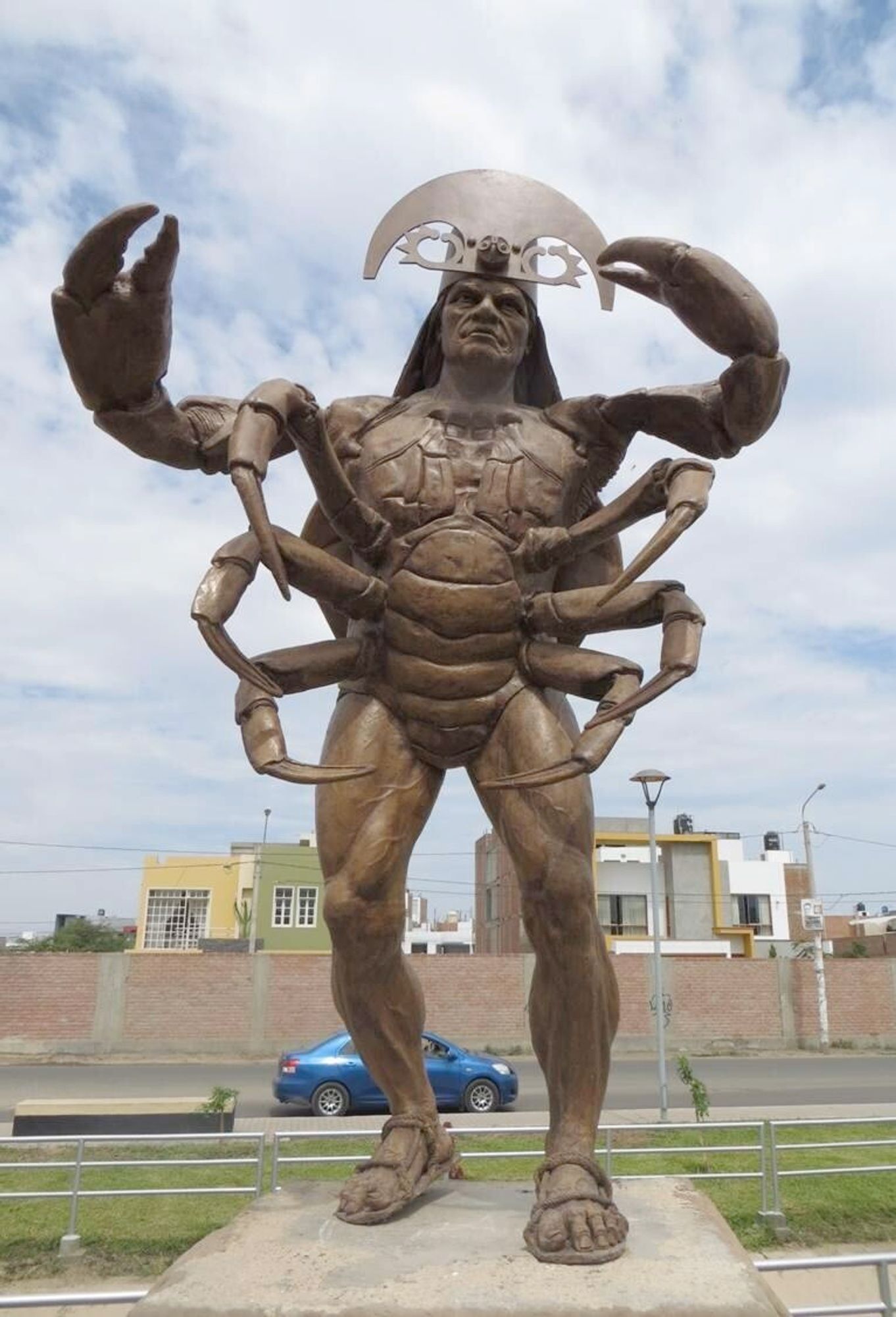 a large statue of a muscular man he is part crab.