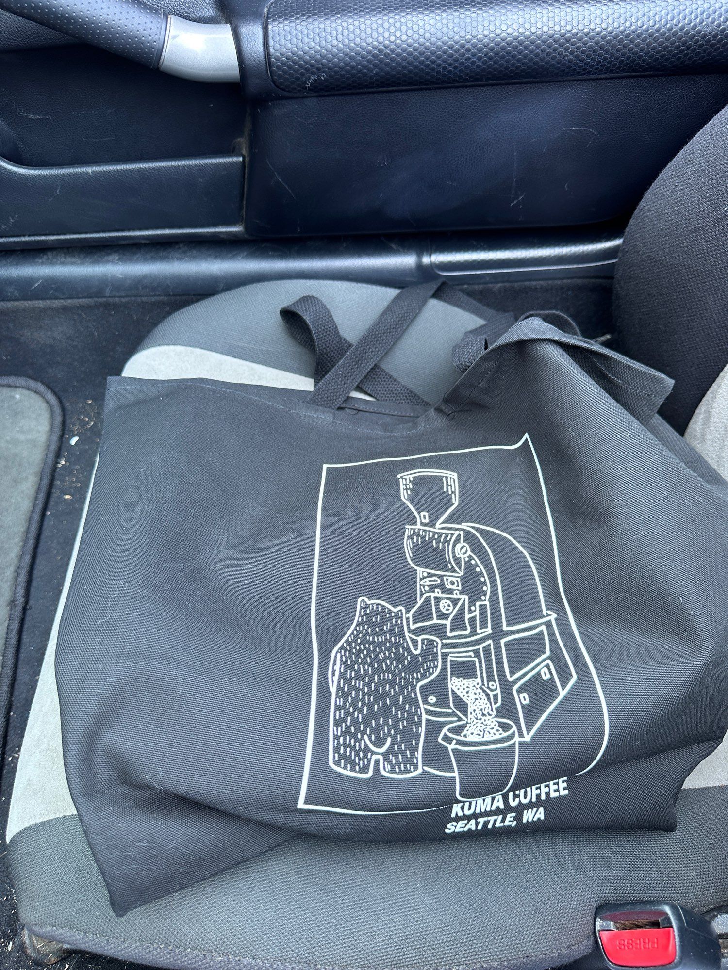 kuma coffee totebag in a car