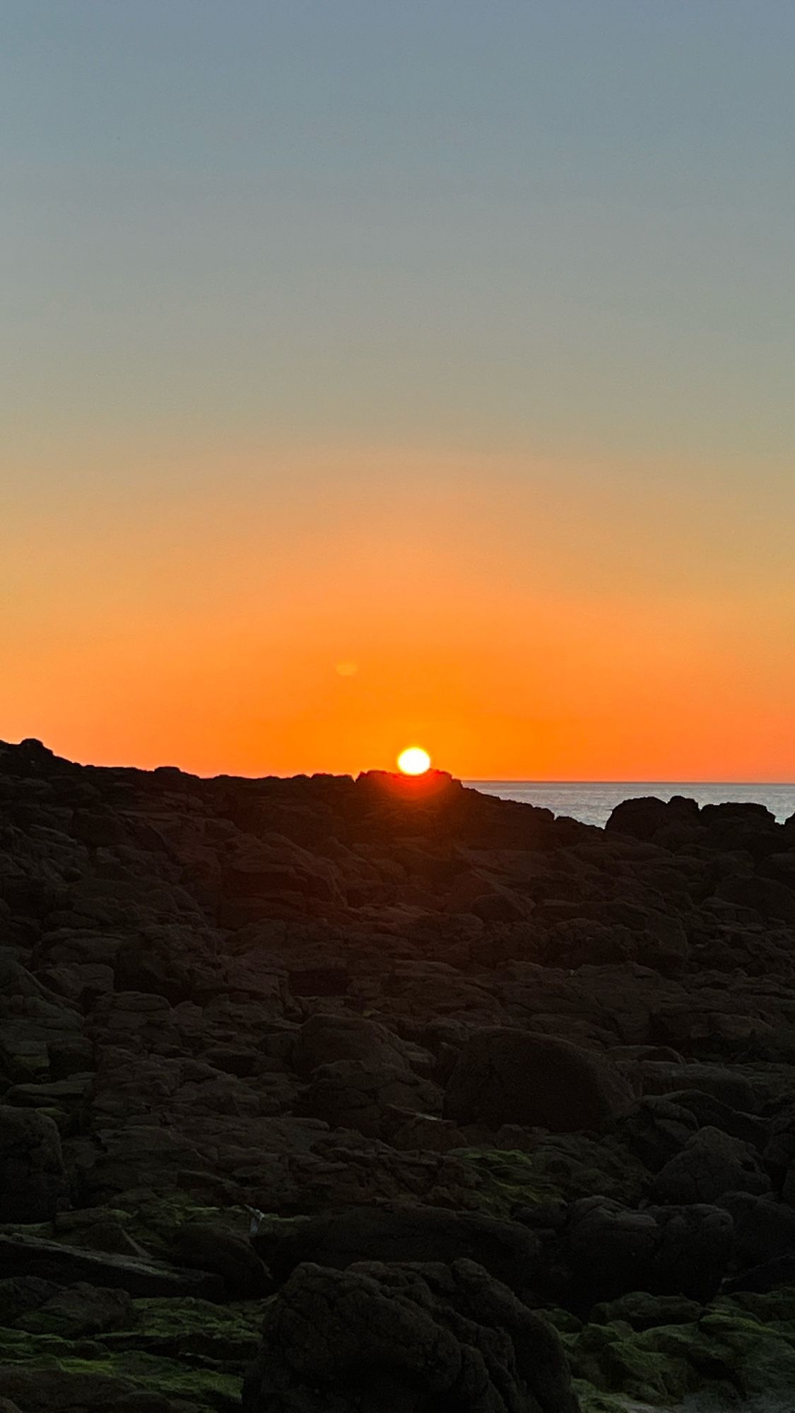 Sonnenuntergang am felsigen Strand