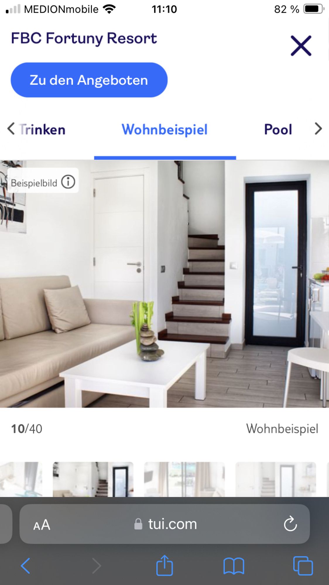 Foto eines Hotelzimmers auf TUI.com. Auf dem Couchtisch steht hinter einem Stapel aus Steinen ein Sellerie.