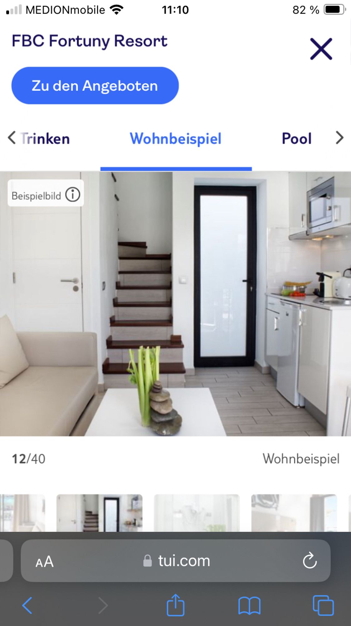 Foto eines Hotelzimmers auf TUI.com. Auf dem Couchtisch steht hinter einem Stapel aus Steinen ein Sellerie.