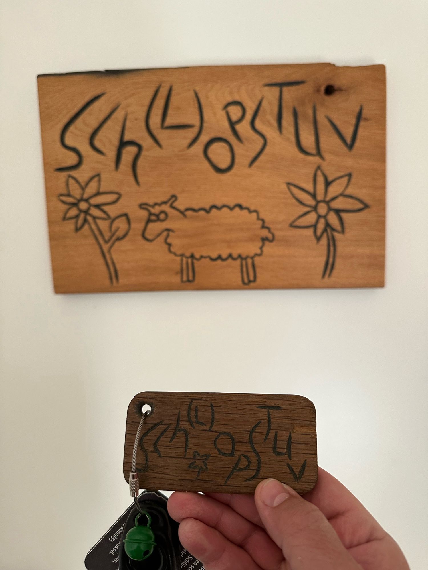 A nearly indecipherable text engraved on a wooden board with a sheep cut in to it. I believe it say Sch(L)opstuv, for which I have no definition other than to assume it has something to do with sheep.