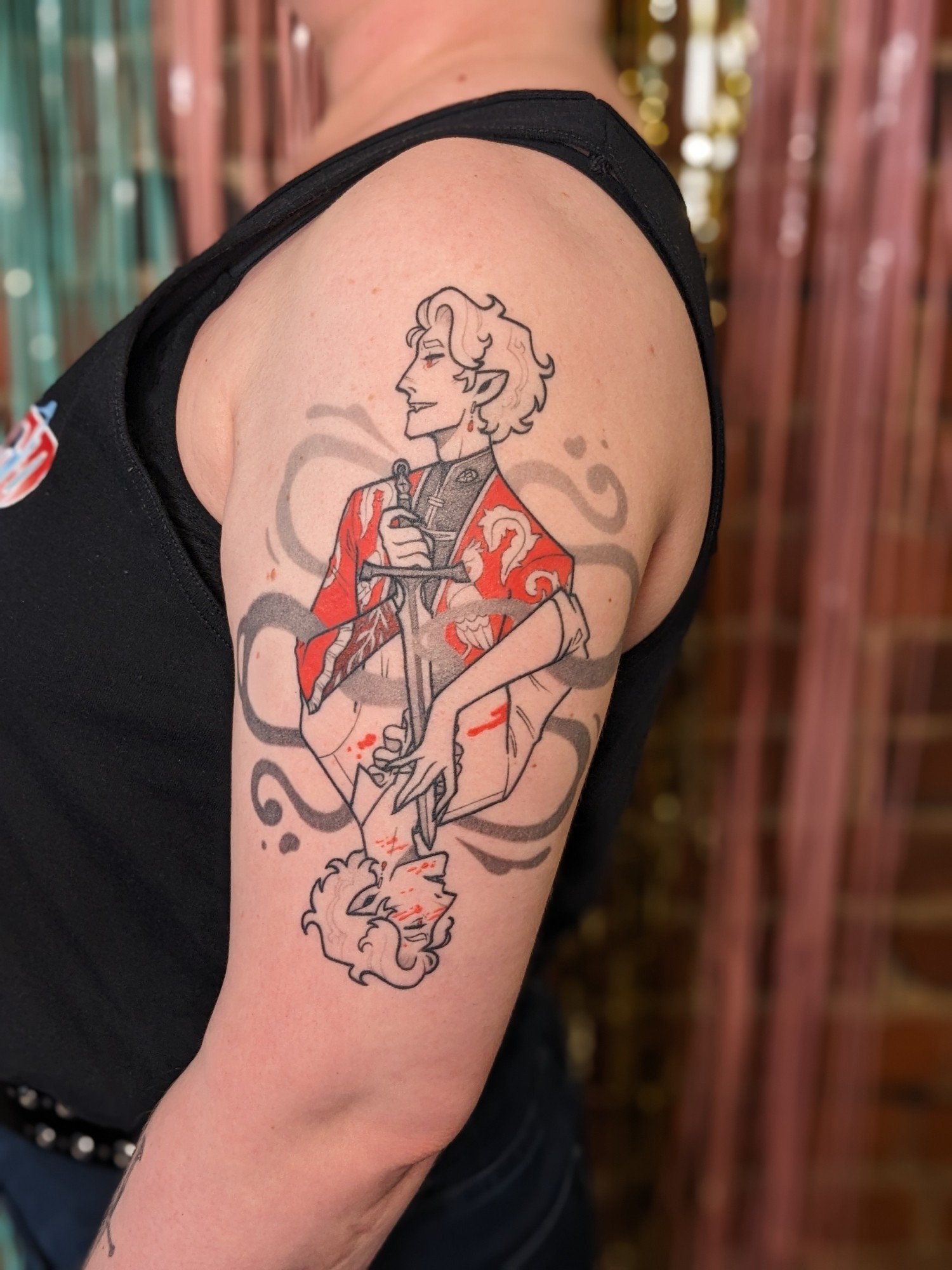 A healed tattoo of Astarion from Baldur's Gate 3. He is set up like the suicide king playing card. It is a rotationally symmetrical design depicting his ascension endings. Upright he is finely dressed, ascended, with a smile, holding a sword down to his reversed form. Reversed, he is bloodied, in his typical outfit, unascended and upset, the tip of the sword to his throat. His hand touches it, as if he can feel it. They are separated by smoke that weaves through the design.