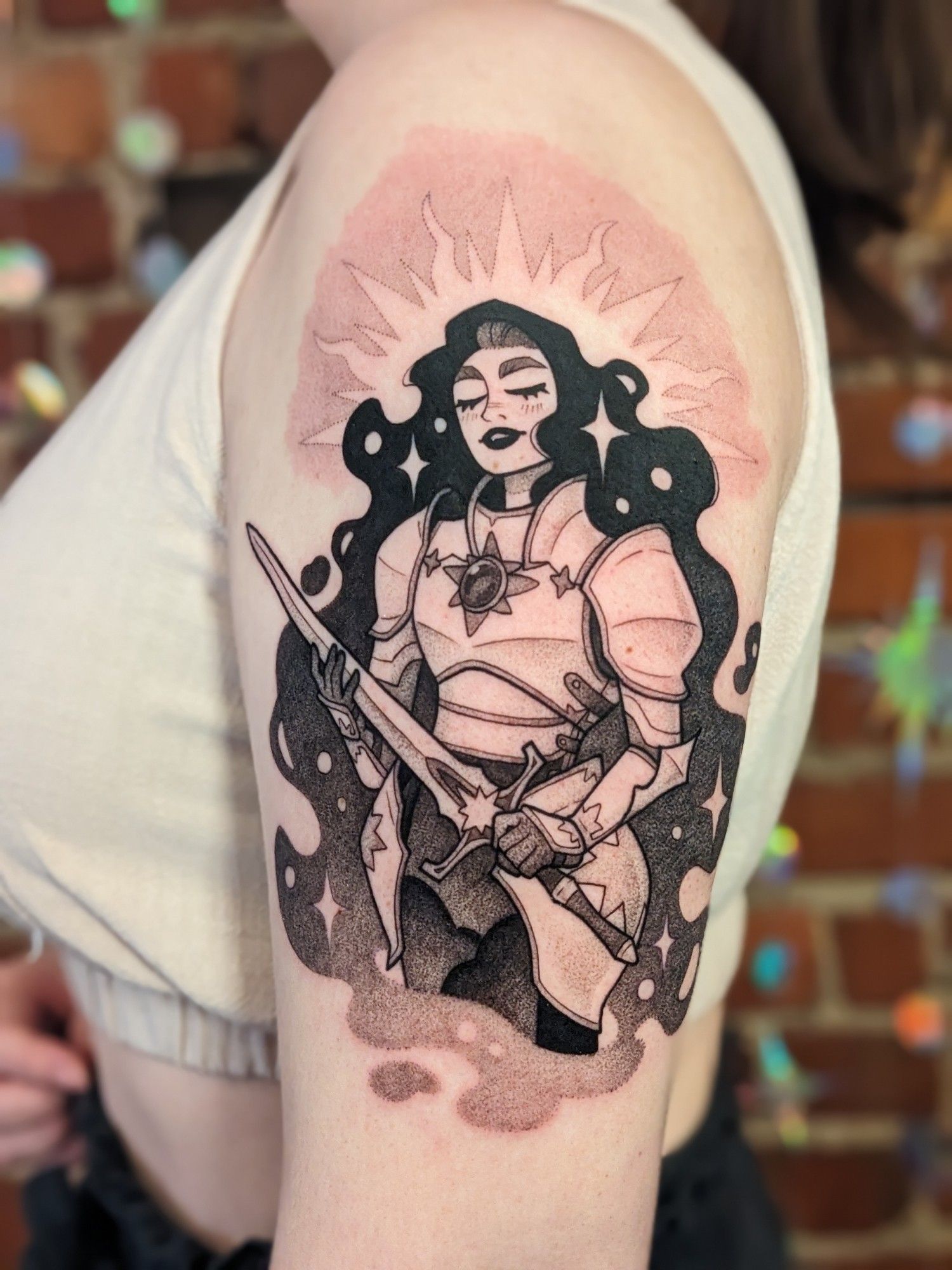 A black and grey tattoo of a serene looking Celestial lady knight.